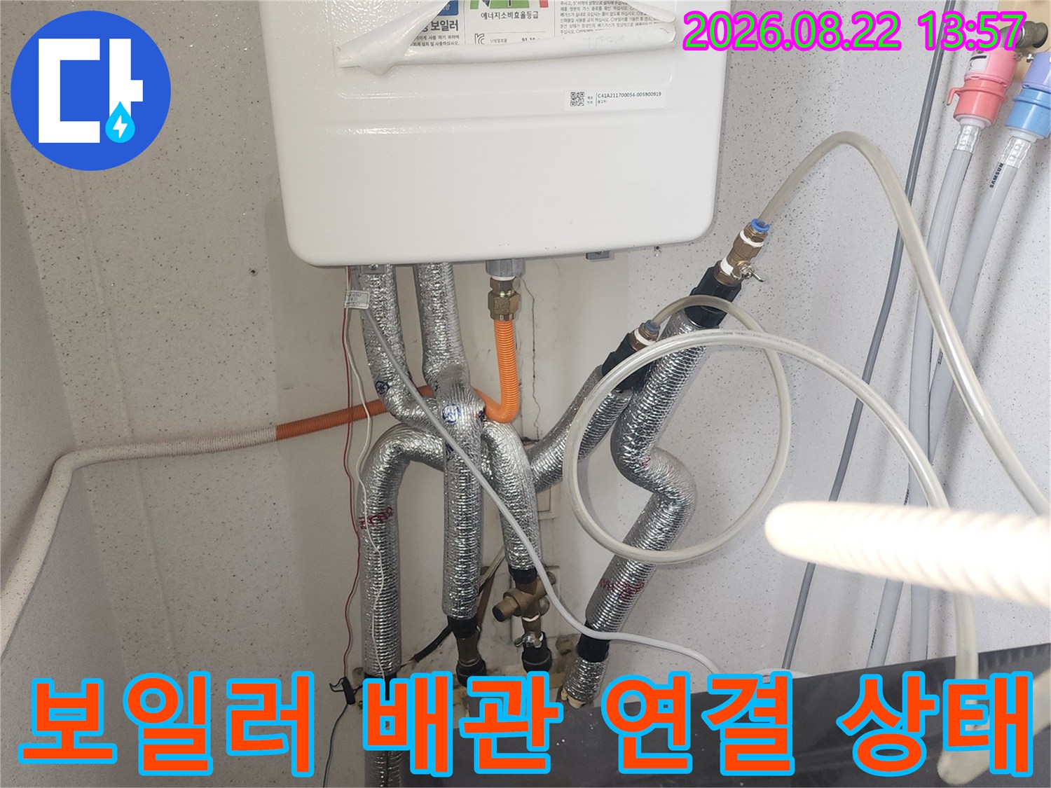 보일러 아래쪽의 보온재 배관과 연결 부위를 점검하는 사진입니다.