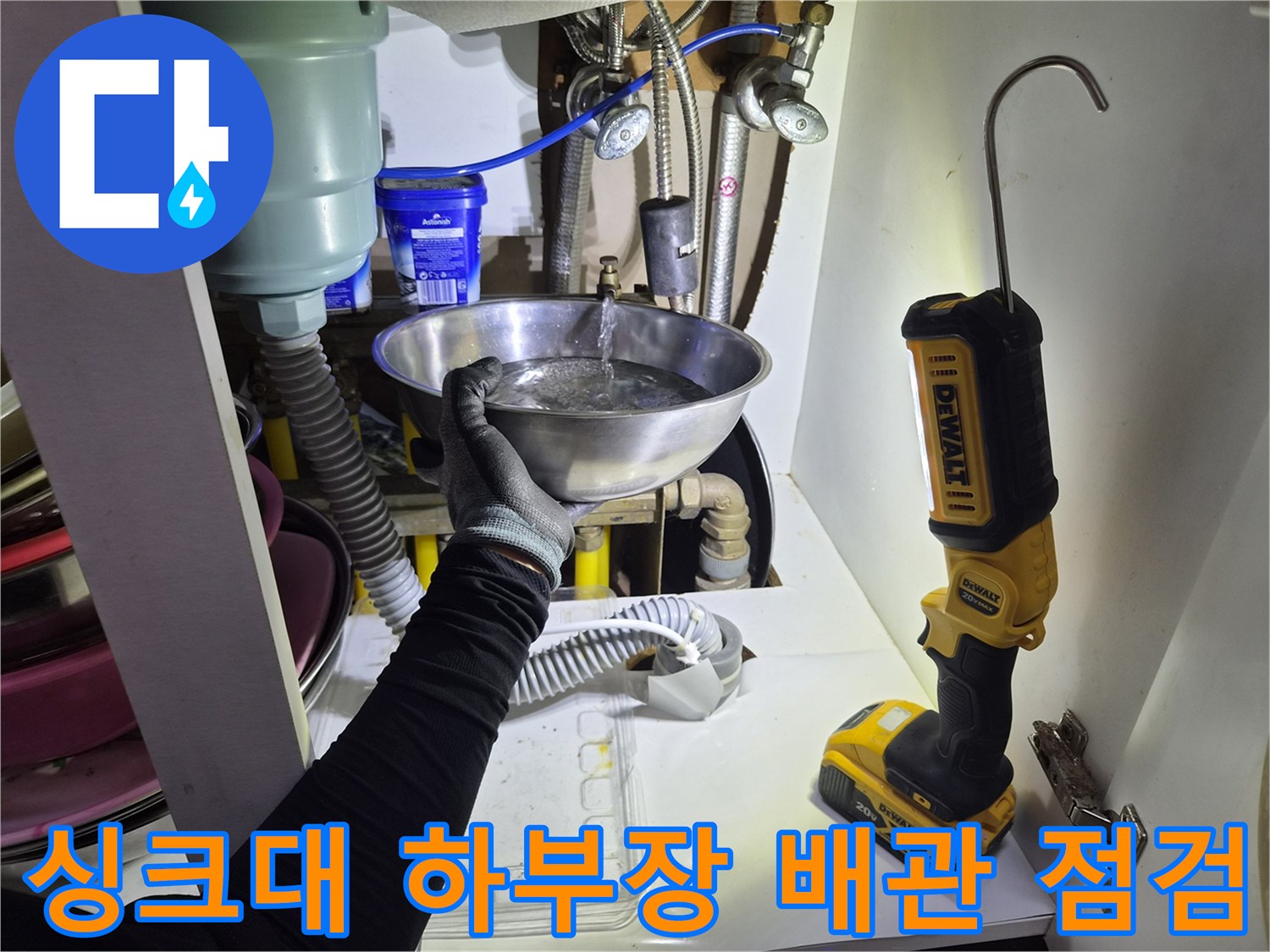 싱크대-하부장-내부-배관-누수-여부를-확인하기-위해-그릇을-받쳐두고-점검하는-모습