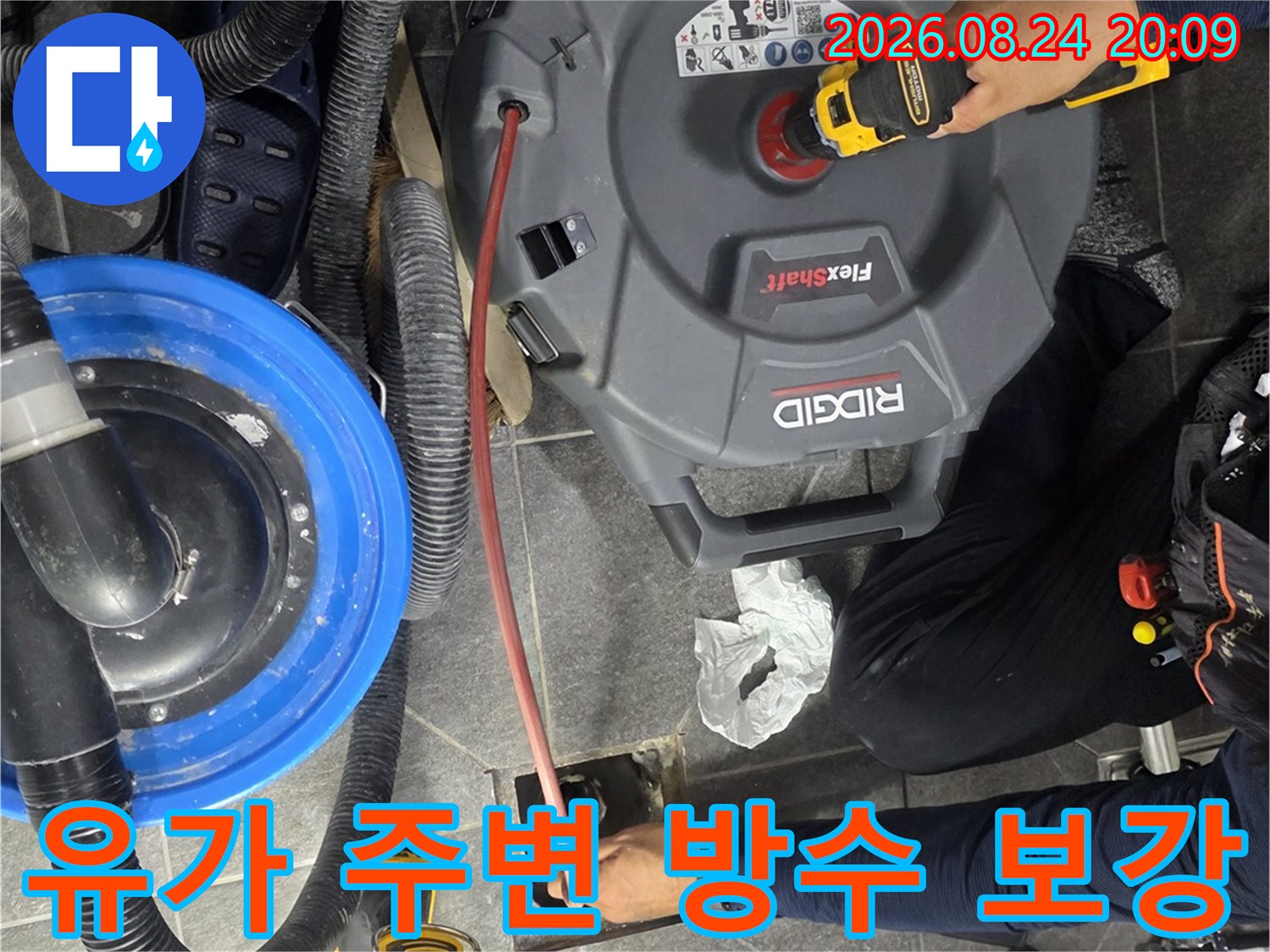 전동 드릴과 청소기를 사용하여 배수구 틈새를 정비하는 모습