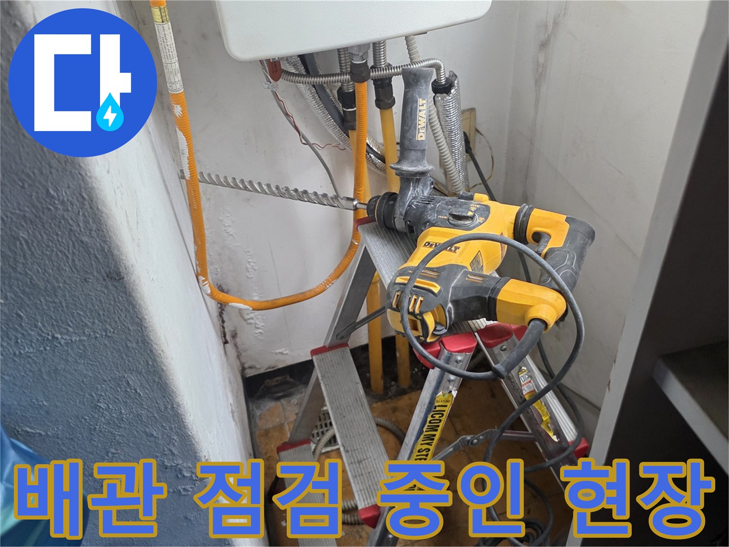 아파트 배관 연결 부위를 점검하기 위해 설치된 사다리와 전동 드릴 장비