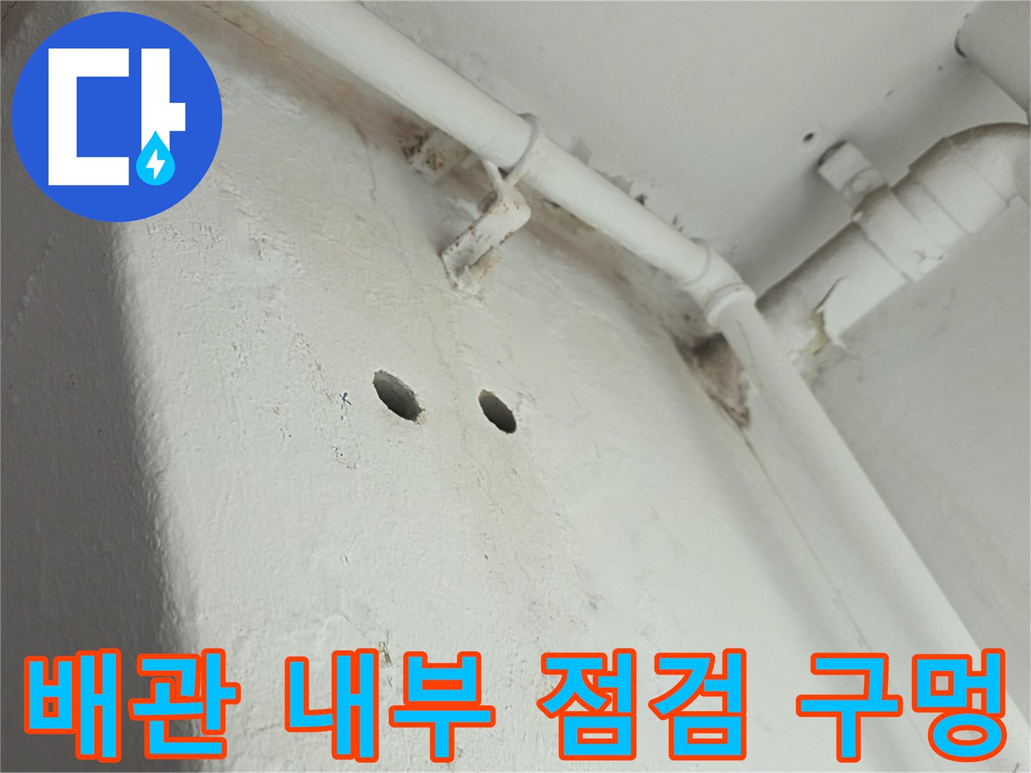 천장 구조물에 뚫린 작은 타공 구멍과 흰색 배관의 모습입니다.