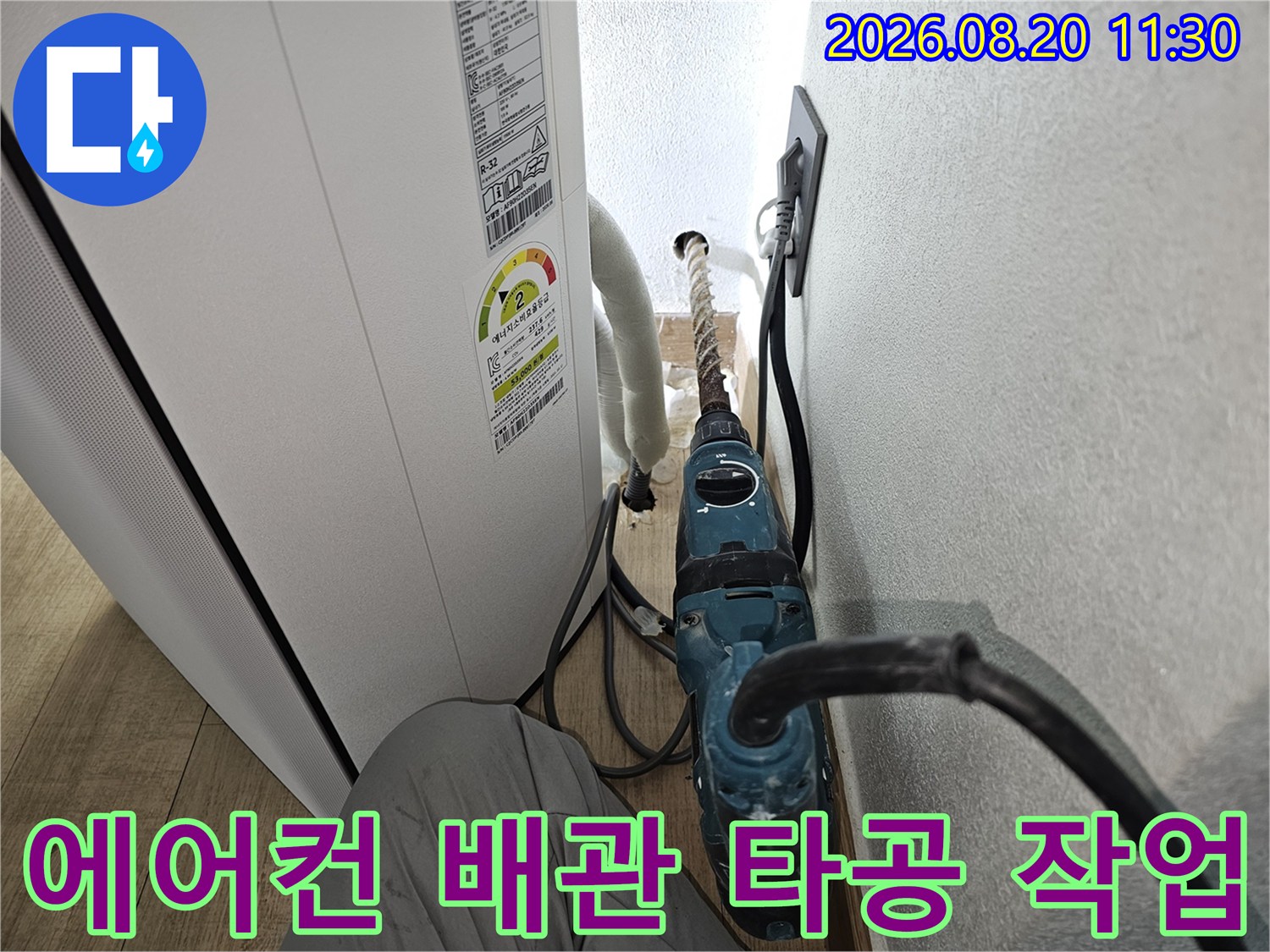 에어컨 드레인 배관 교체를 위해 벽면을 타공하는 공사 현장 모습입니다.