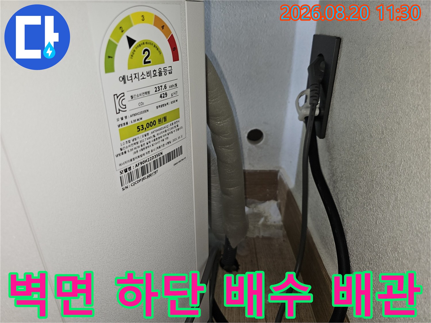 에어컨 아래쪽 벽면-배수 호스와 전기 플러그의 근접 사진