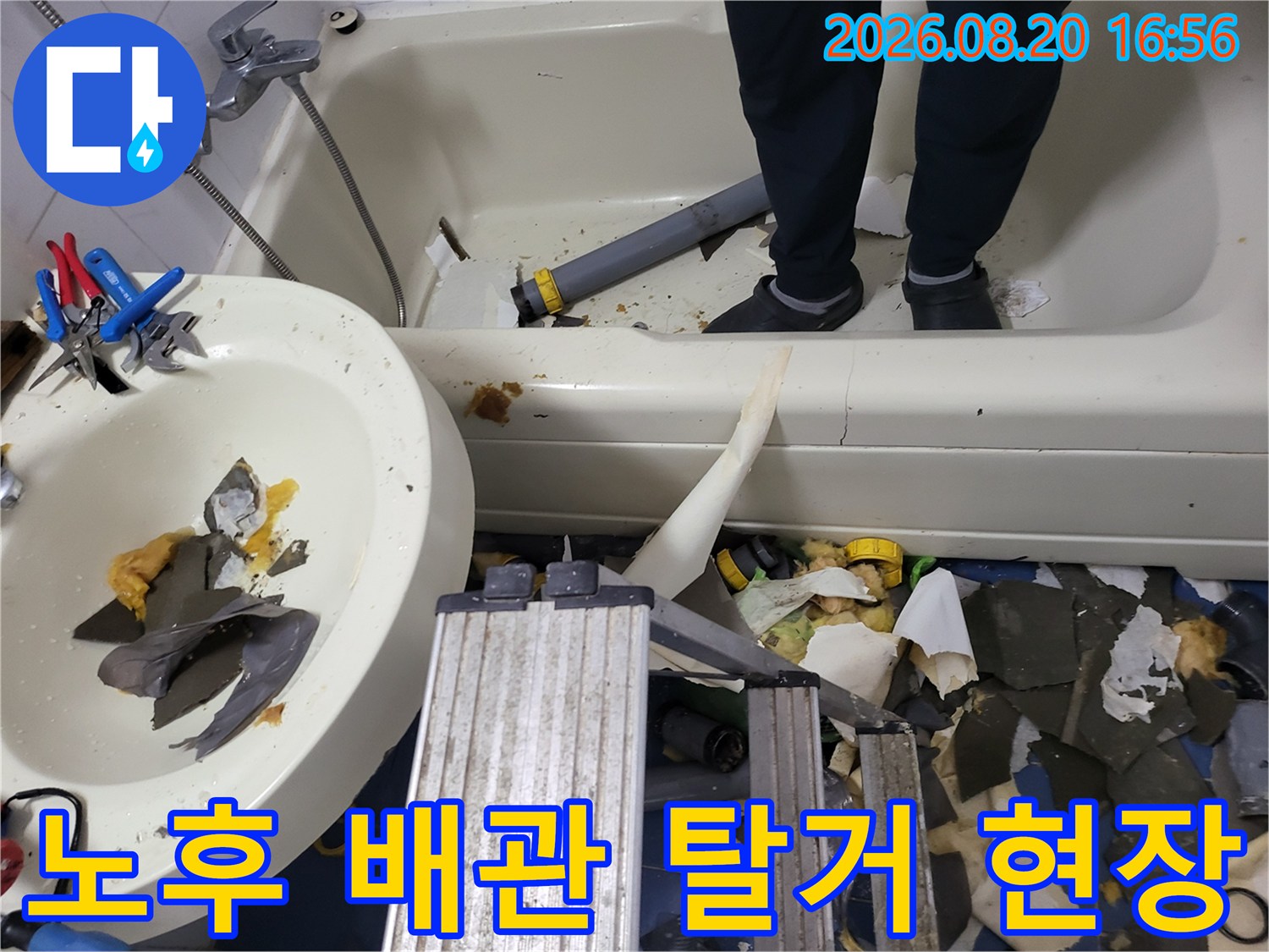 욕조 내부에 배치된 수리용 공구와 분리된 배관 부품