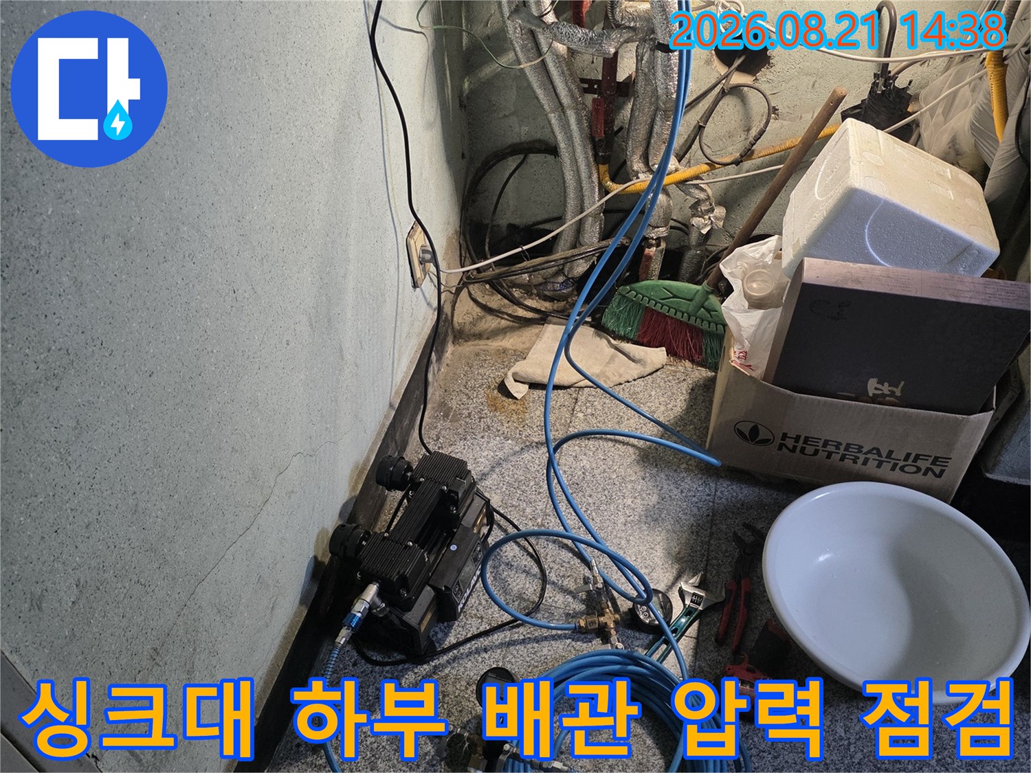 싱크대 아래 복잡한 배관과 연결된 누수 탐지용 호스 라인