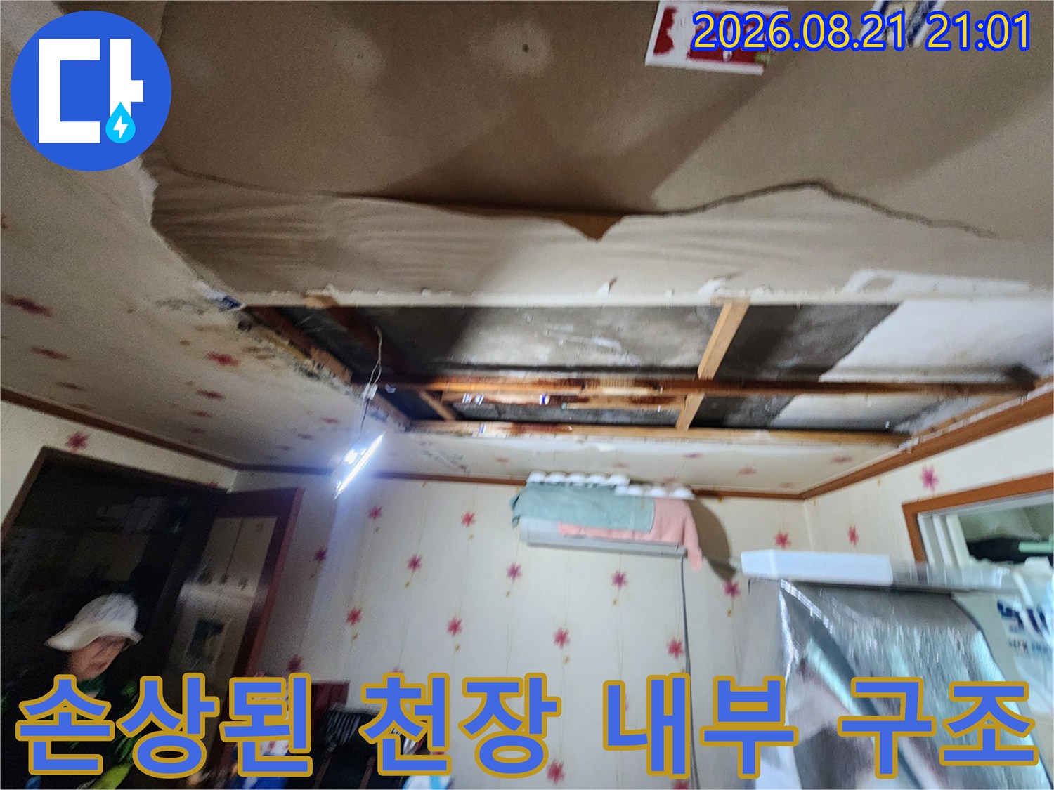 누수로 인해 찢어지고 들뜬 천장 마감재와 내부 노출 부위입니다.