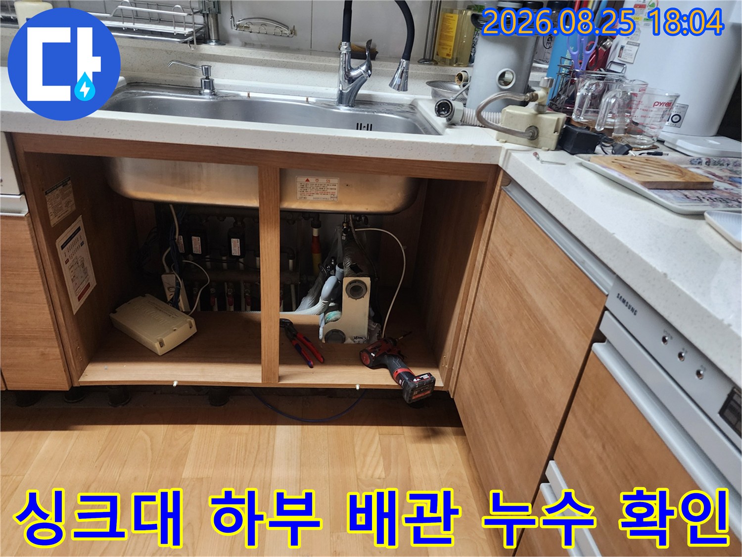 싱크대 아래쪽 수납 공간에 노출된 배수 호스와 연결 부위 점검 현장