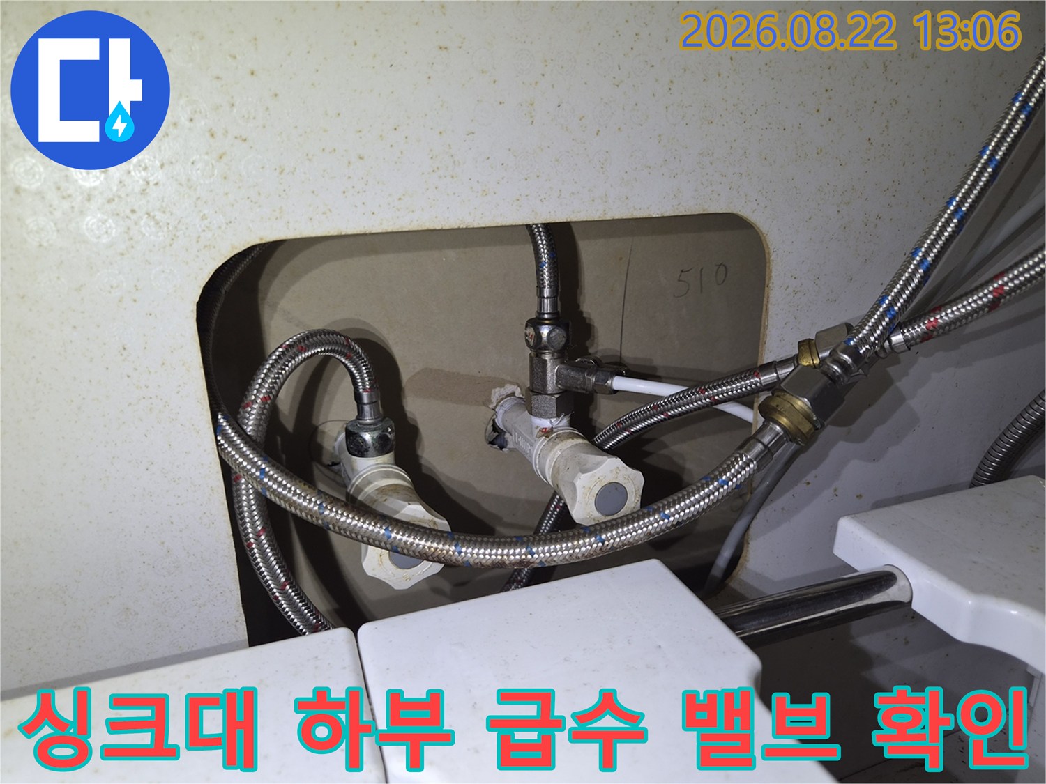 싱크대 아래쪽 금속 호스와 밸브가 연결된 배관 부위의 상세 사진입니다.