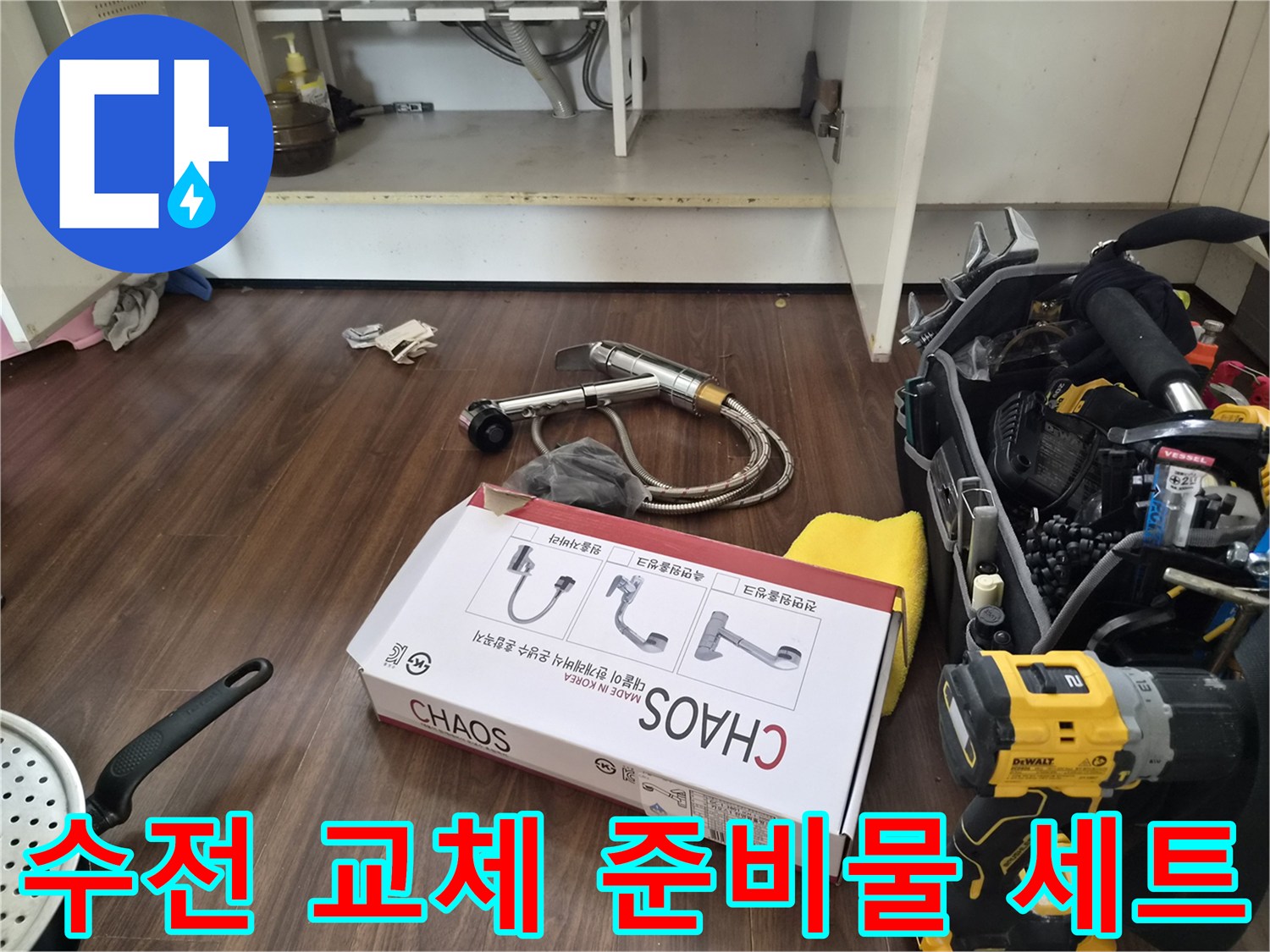 싱크대 하부 작업 공간에 배치된 새 수전 패키지와 전동 공구들