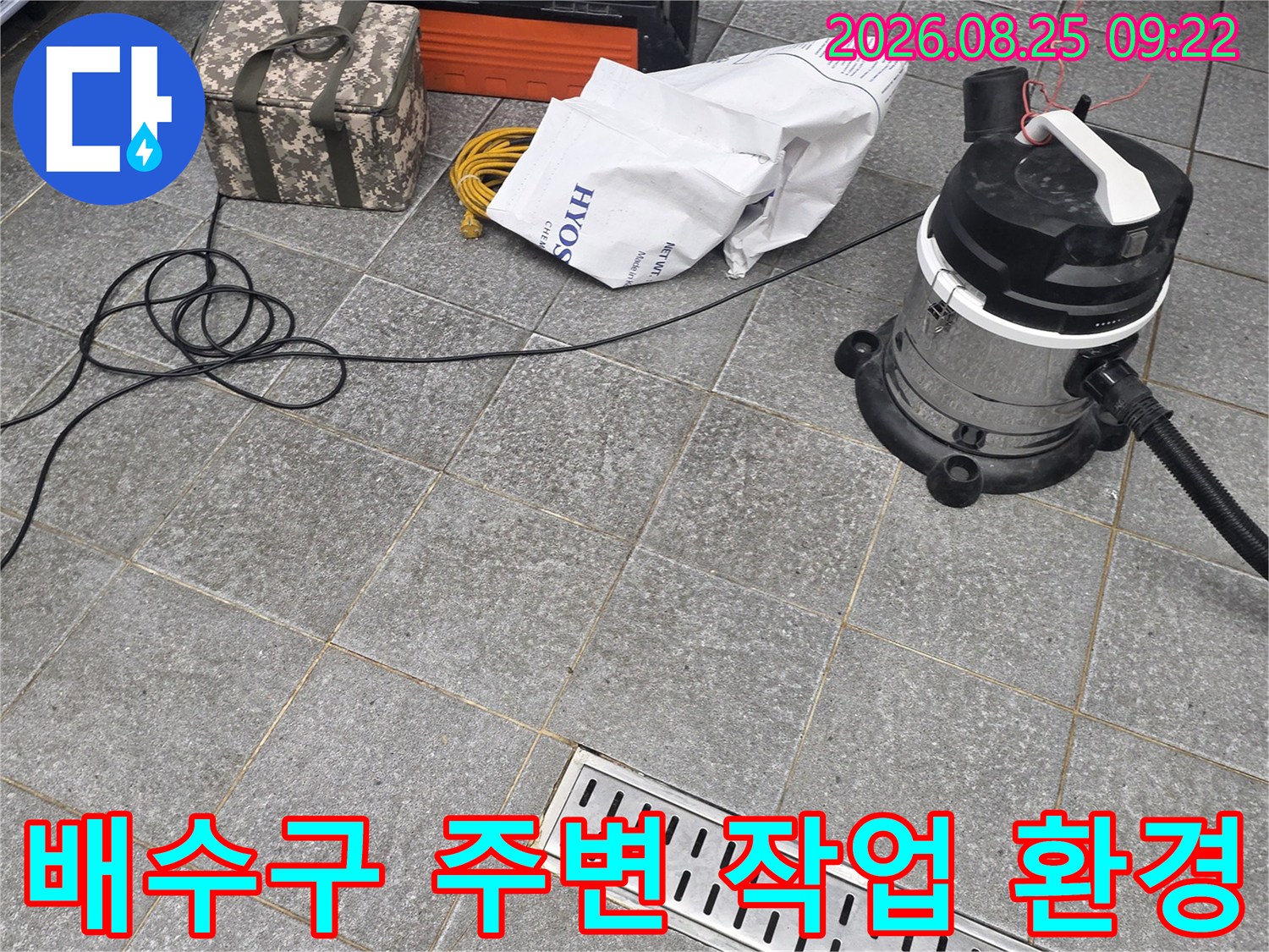 트렌치 배수구와 그 옆에 놓인 청소기 및 공구들의 배치 상태입니다.