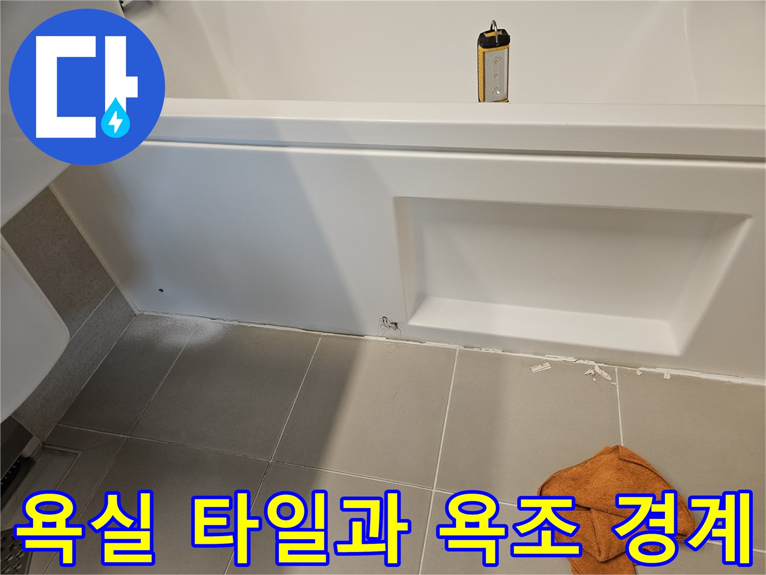 욕조 옆면 패널 아래쪽의 벌어진 틈새를 근접 촬영한 사진