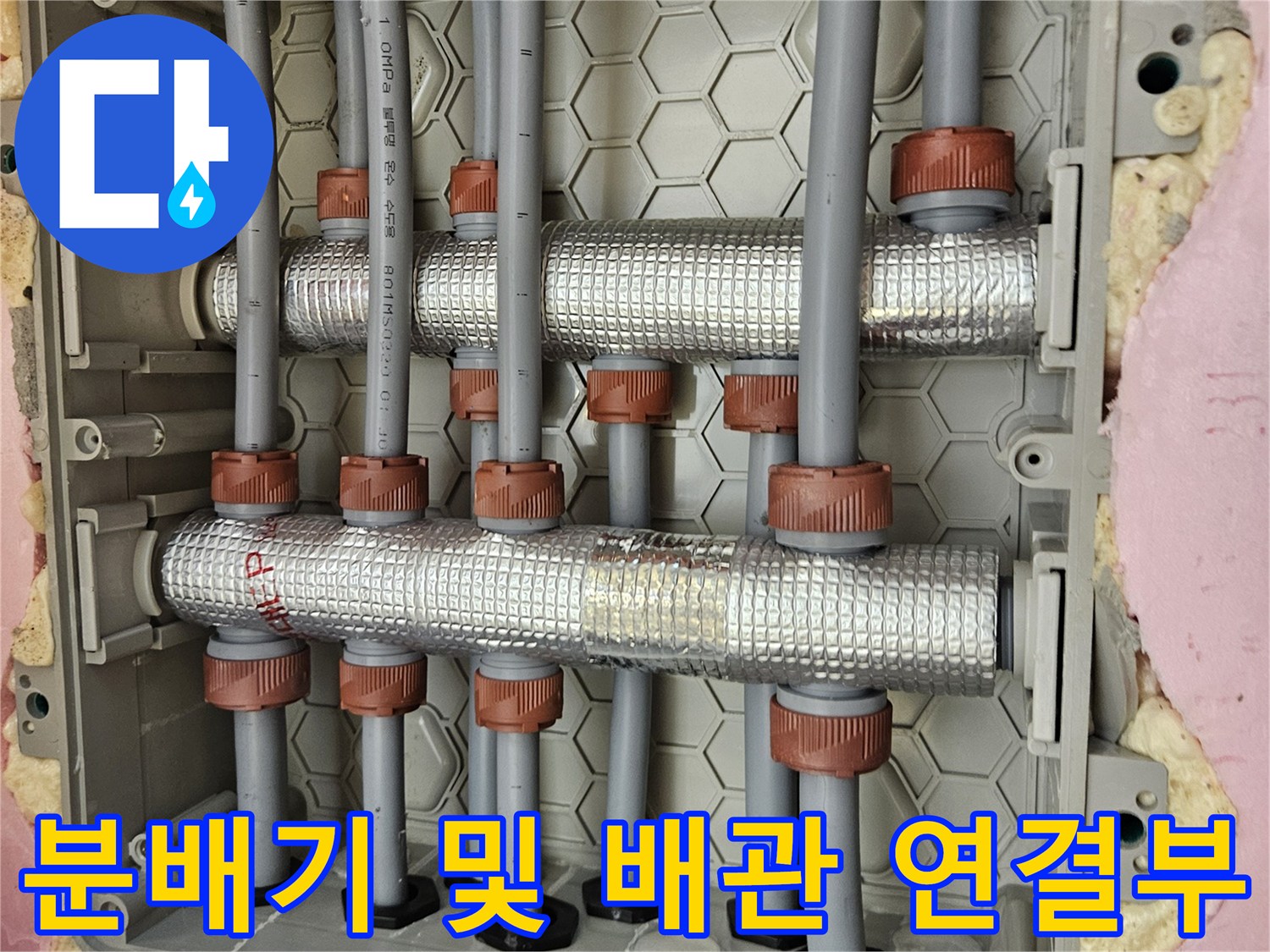 천장 내부 수전 분배기와 은박 보온재로 감싸진 배관 모습