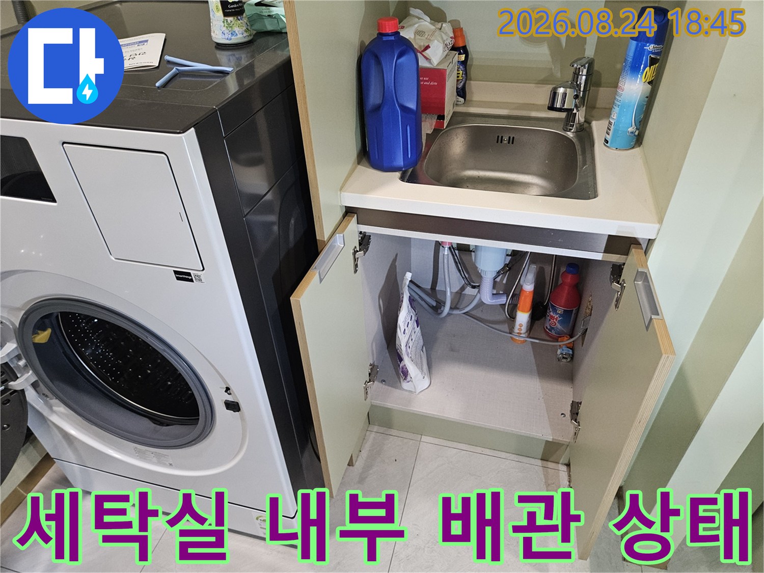 세탁기 옆 선반 아래에 있는 세탁실 배관 및 세제 보관 모습