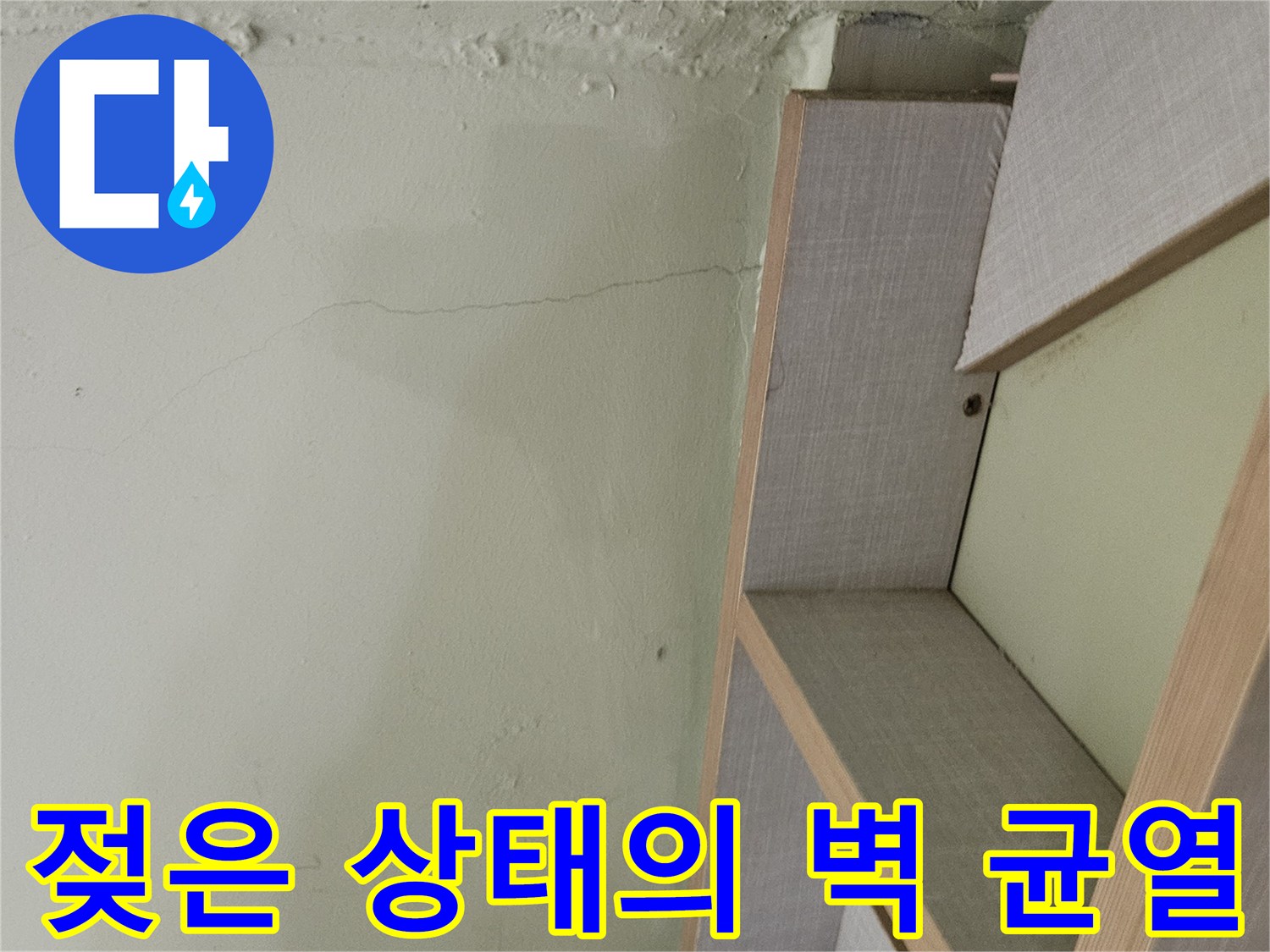 수직 방향으로 발생한 벽면 균열과 습기로 인한 변색 부위