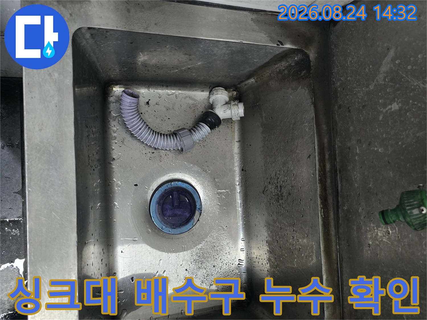 식당 싱크대 내부의 파란색 배수 트랩과 연결된 호스 사진