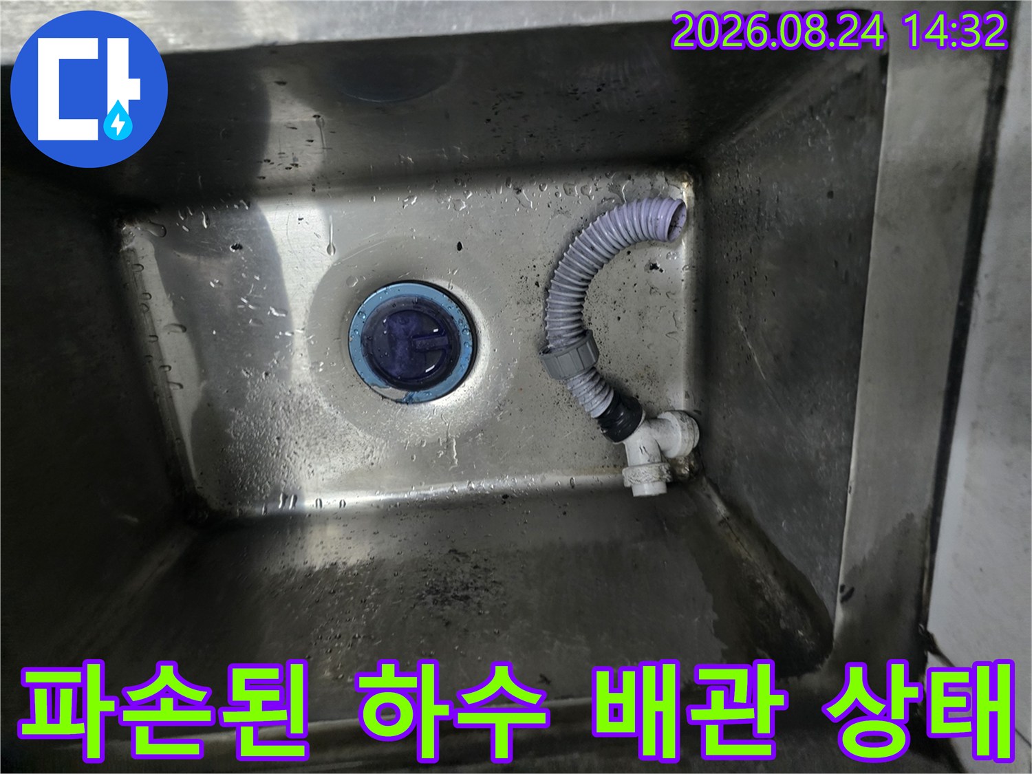싱크대 내부 스테인리스 바닥에 고여 있는 물과 파손된 배관 연결부