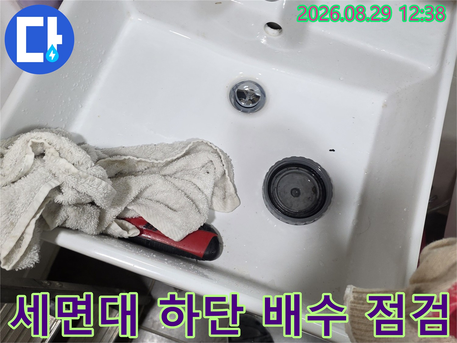 세면대 팝업 장치와 수전의 연결 상태를 근접 촬영한 사진입니다.