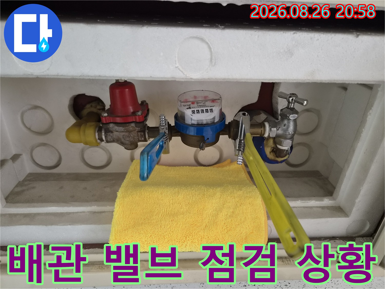 계량기함 내부에 설치된 파란색 밸브와 수도 계량기를 보여줍니다.