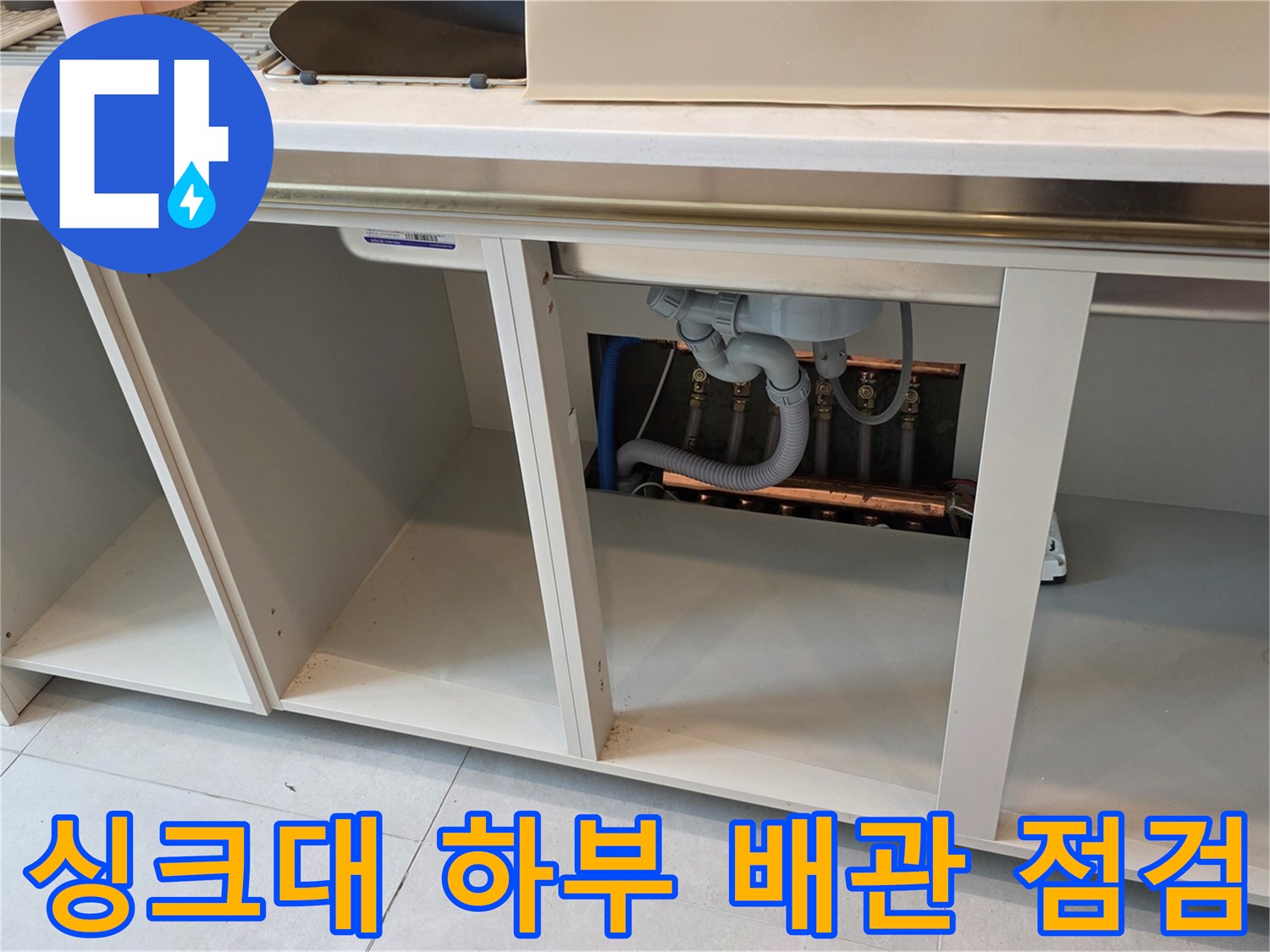 주방 싱크대-하부장 내부의 복잡한 배관 연결 상태
