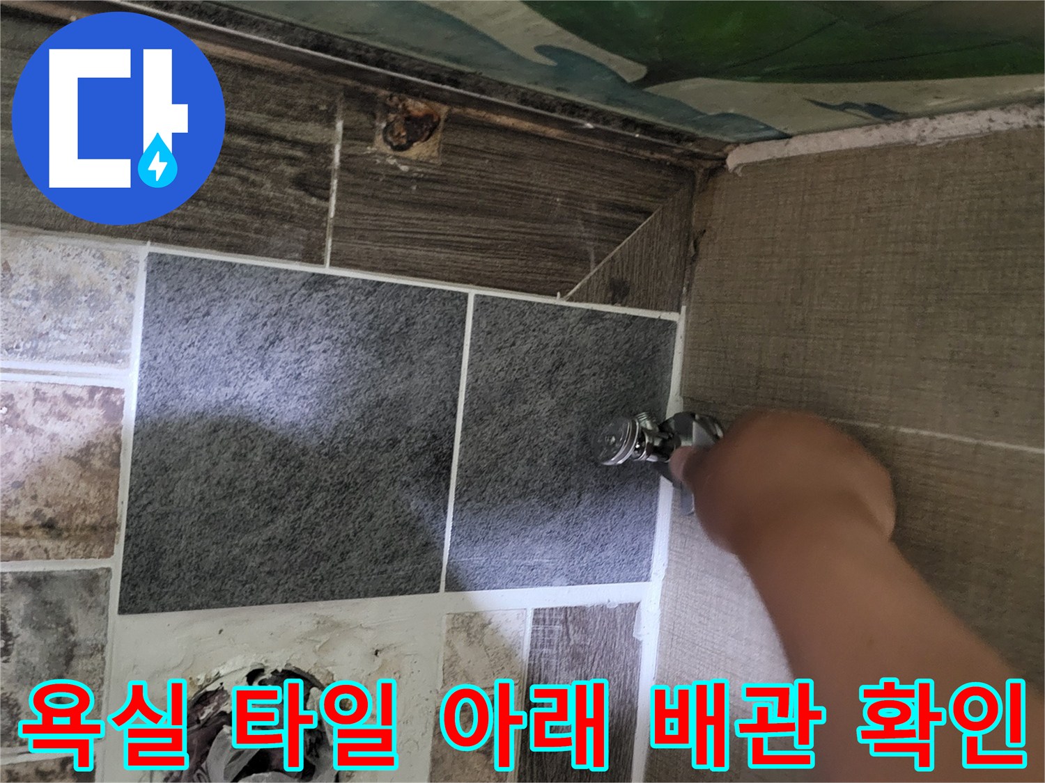 변기 하부 오수관 주변의 누수 지점을 찾기 위해 타일을 제거한 현장 사진입니다.