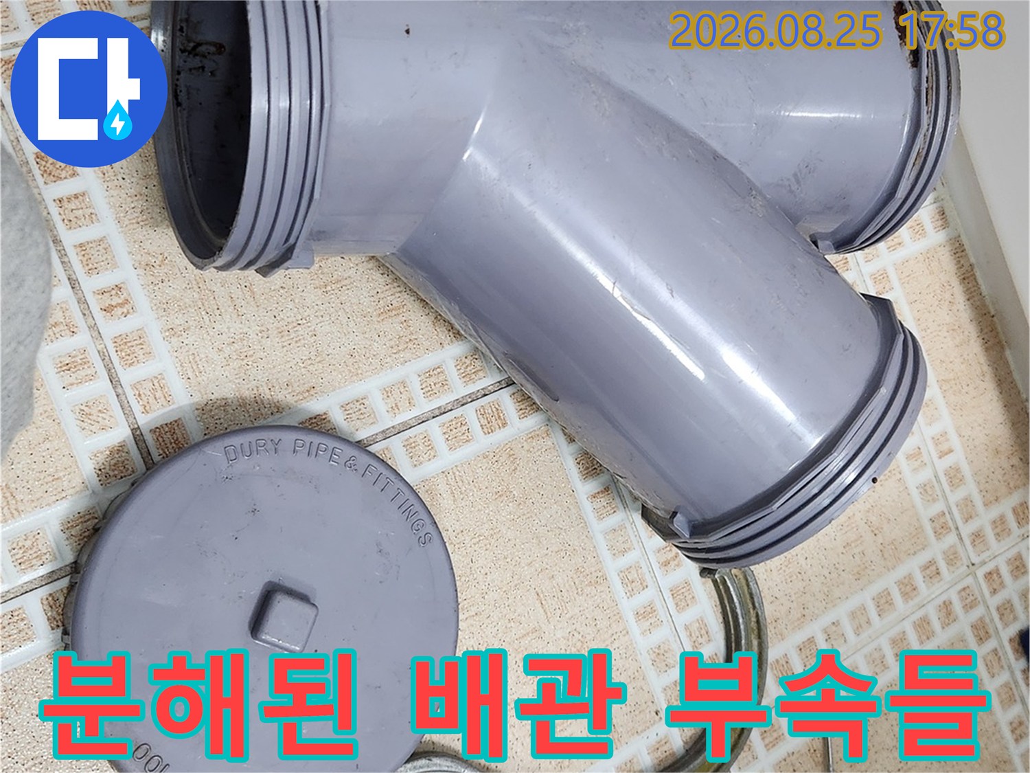 탈거된 회색 오수관 부속과 작업용 렌치 및 드라이버 이미지