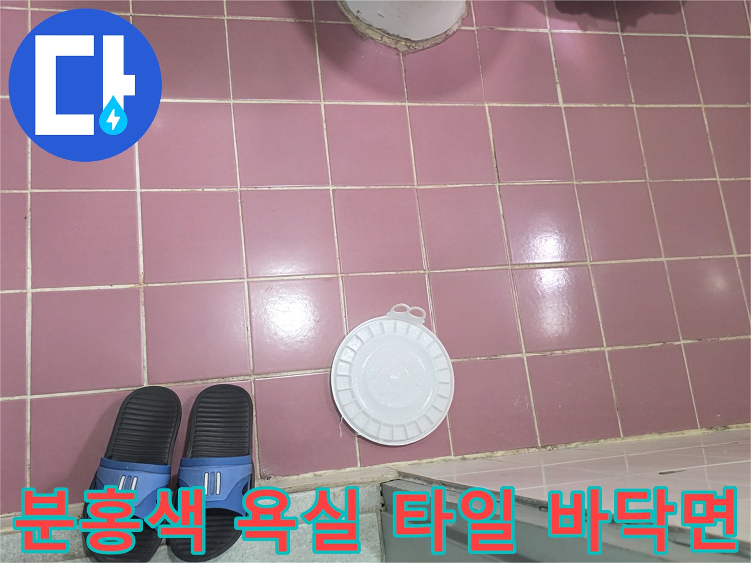 깨끗하게 정리된 분홍색 화장실 타일과 배수구 부속