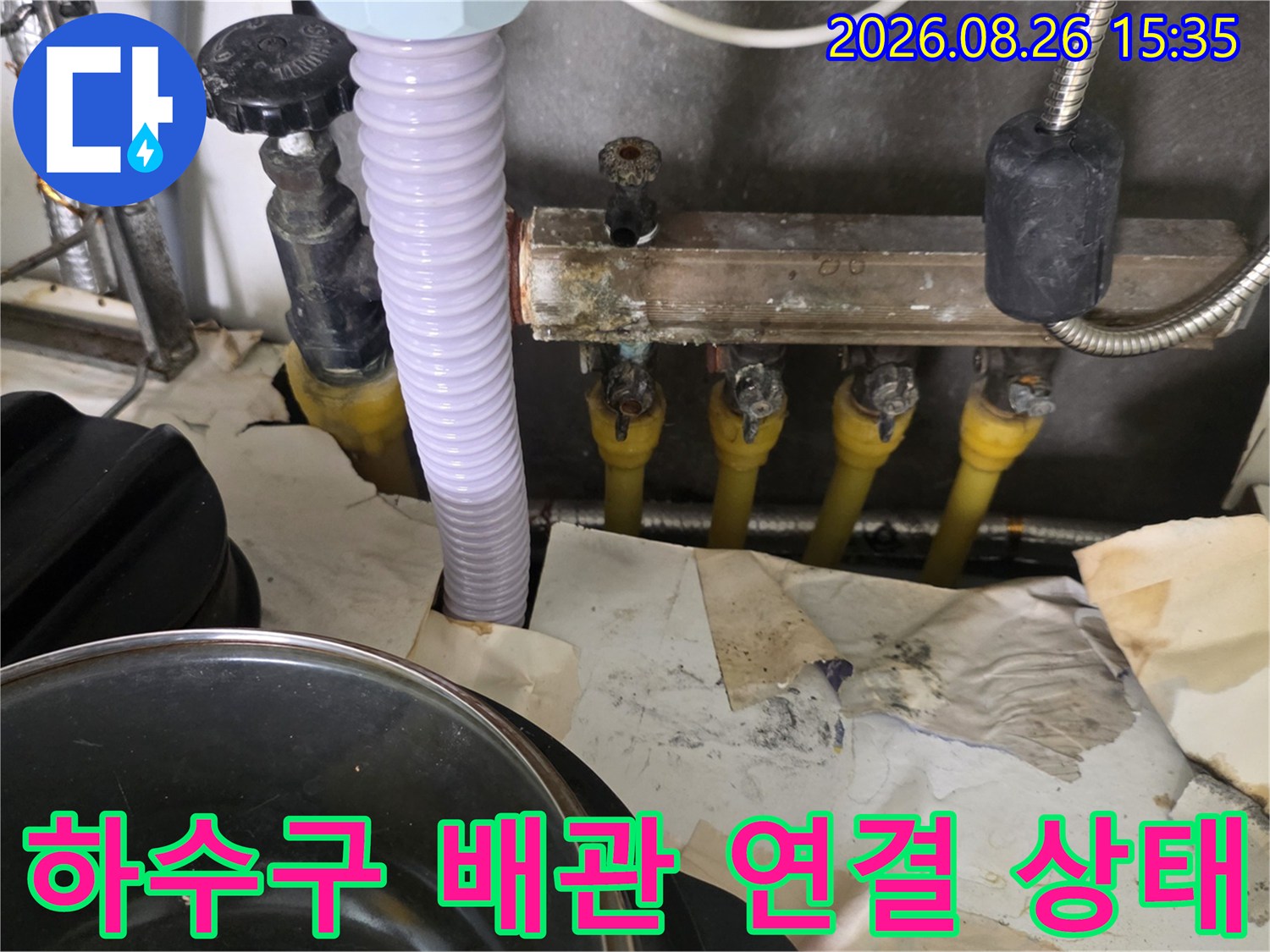 노란색 배관 부속과 호스가 연결된 내부 모습입니다.