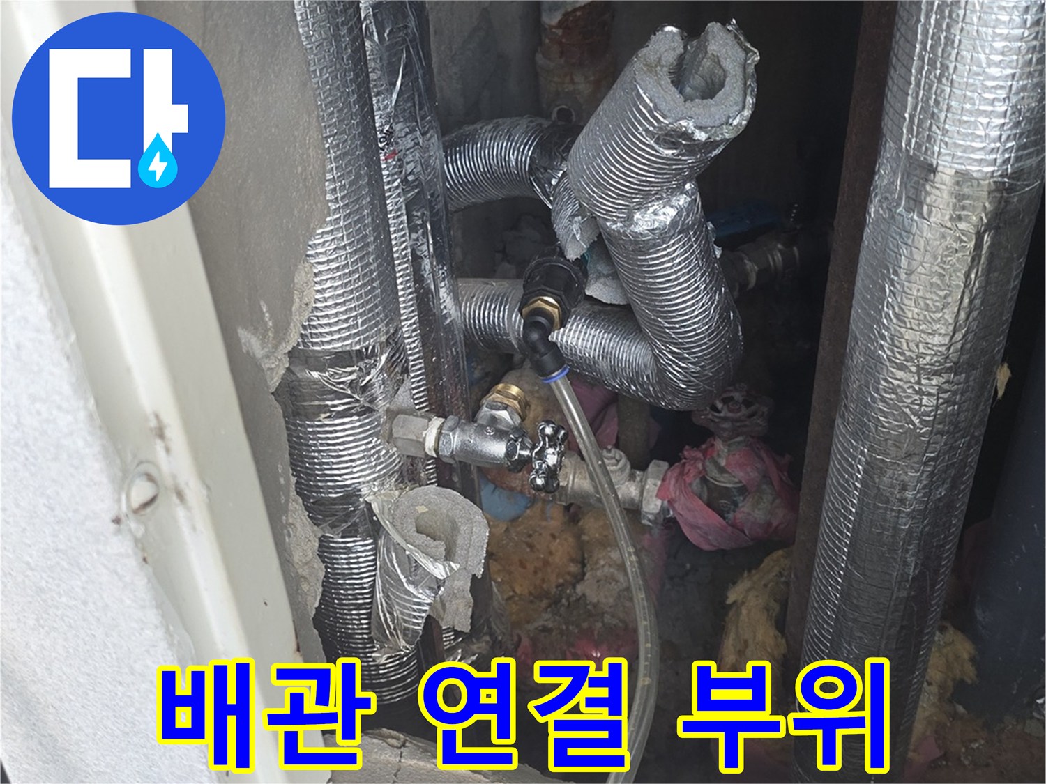 은박 보온재로 감싸진 배관의 굴곡진 연결 부분을 촬영했습니다.