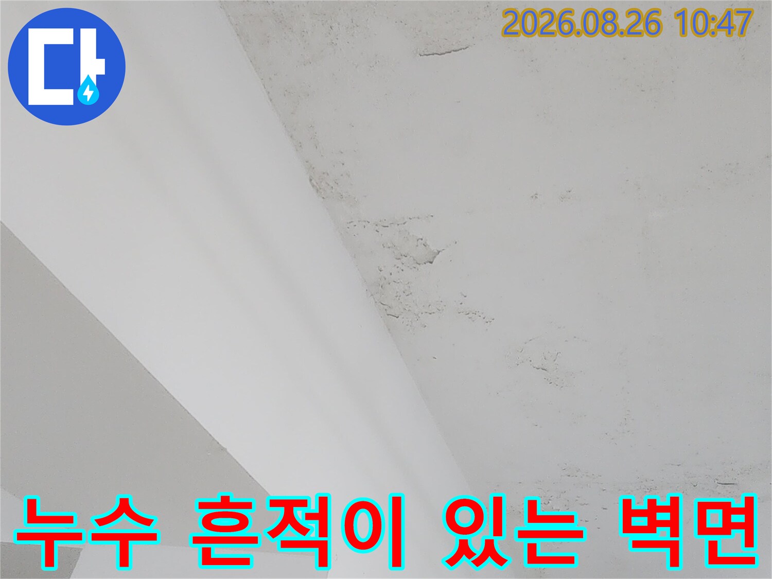 누수로 인해 얼룩진 하얀 벽면과 구조물 모서리 부분의 모습입니다.