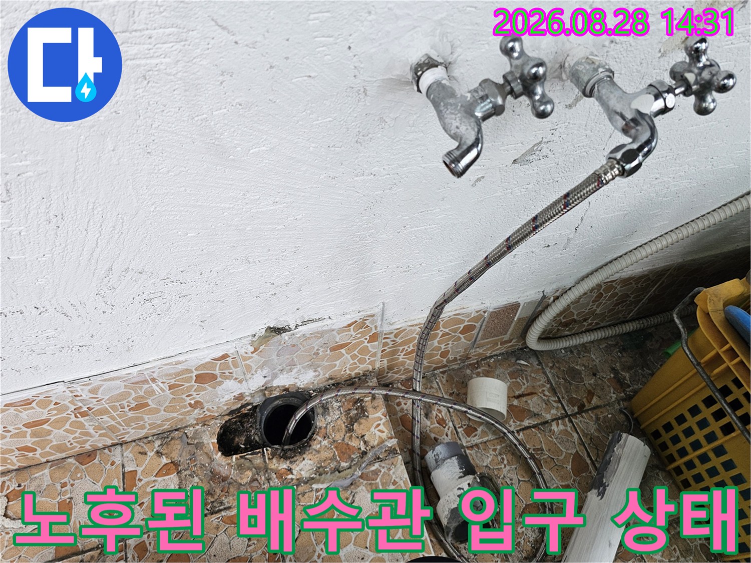 바닥 배수구와 수도꼭지 호스가 연결된 노후 배관 현장 모습입니다.