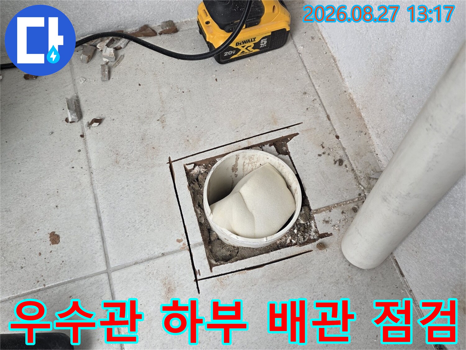 노출된 우수관 배관과 파헤쳐진 바닥 타일입니다.