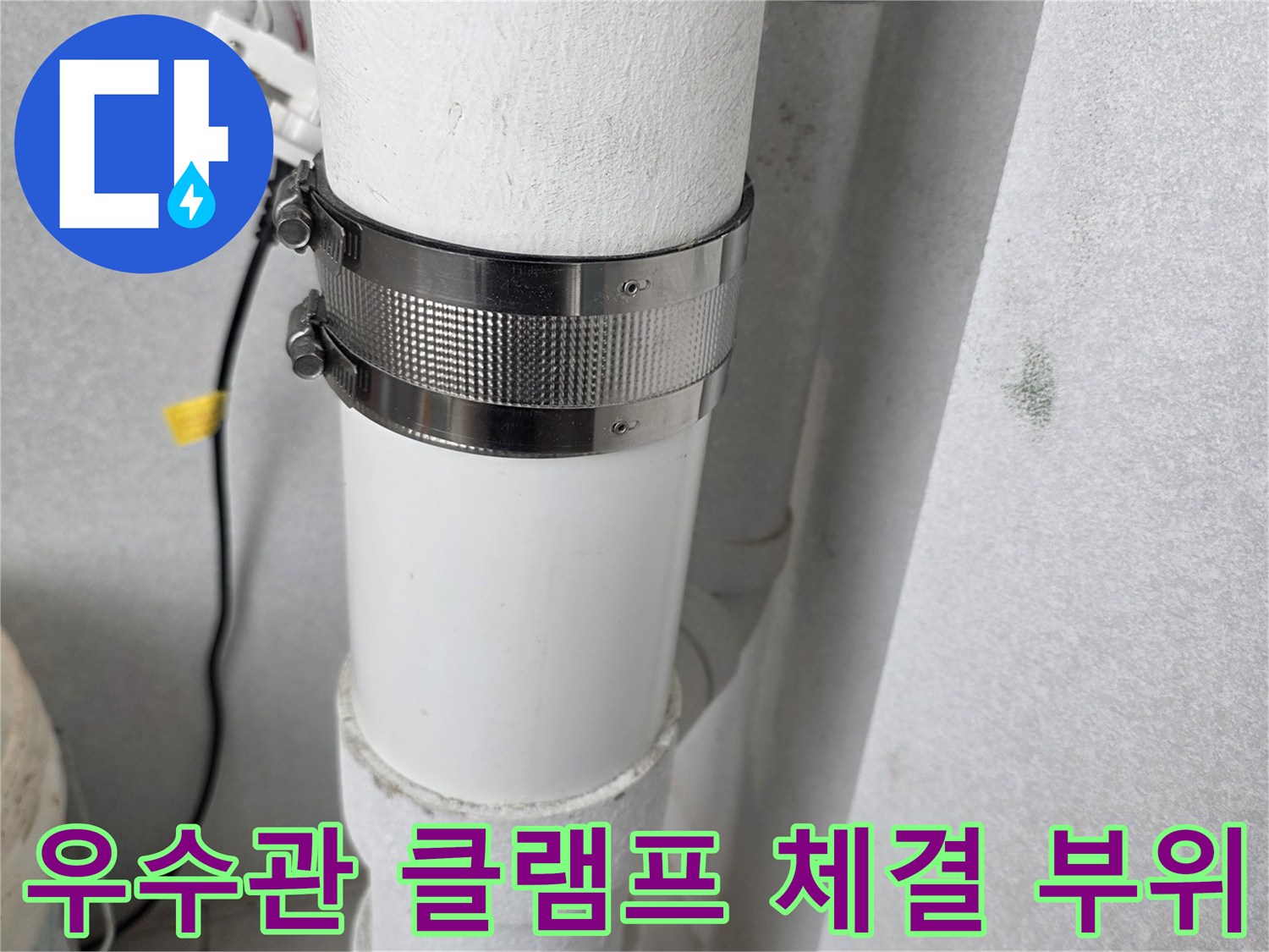 배관 연결을 고정하는 금속 밴드와 우수관의 모습