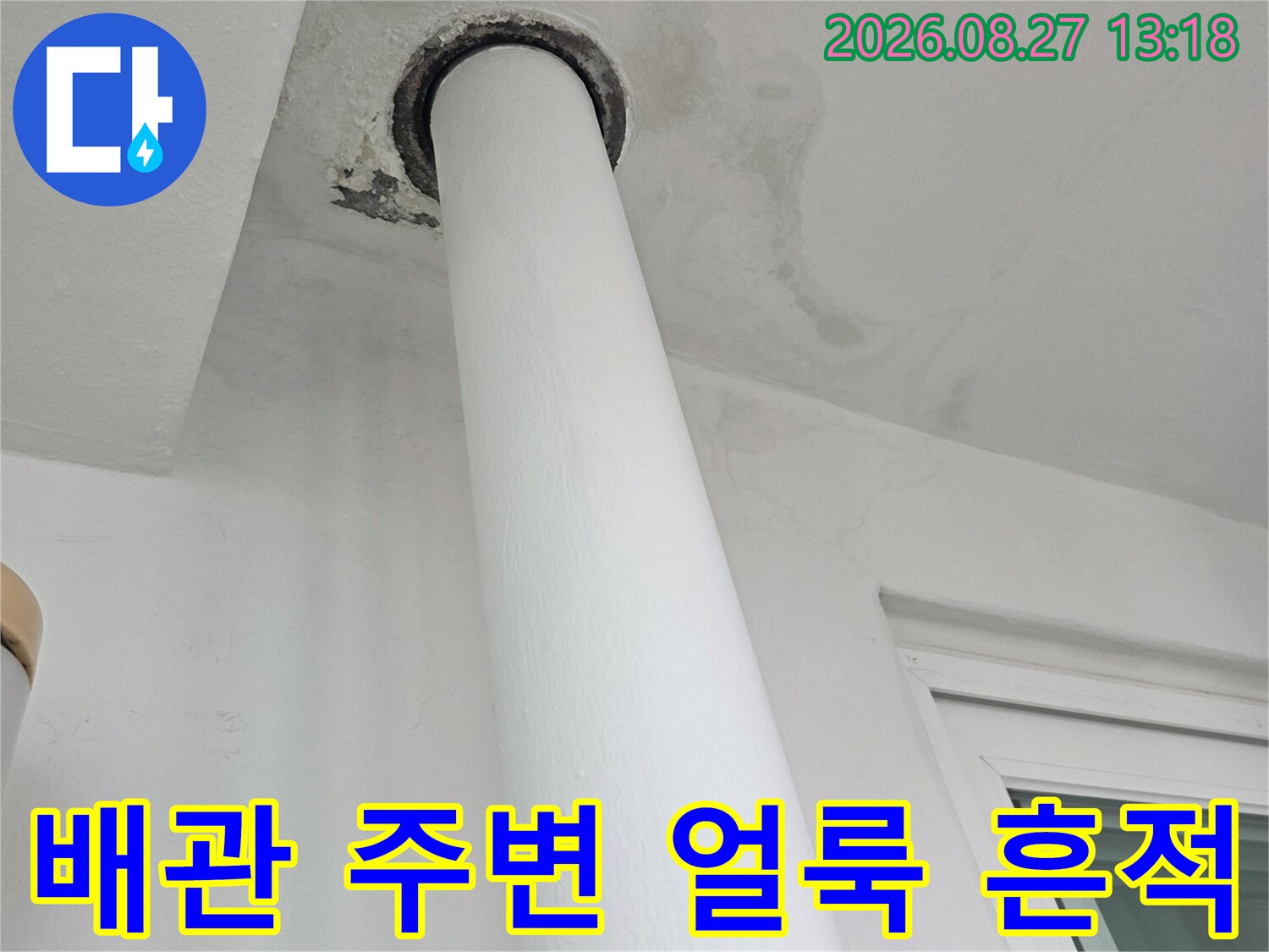 흰색 배관과 벽면 사이의 어두운 누수 자국 촬영