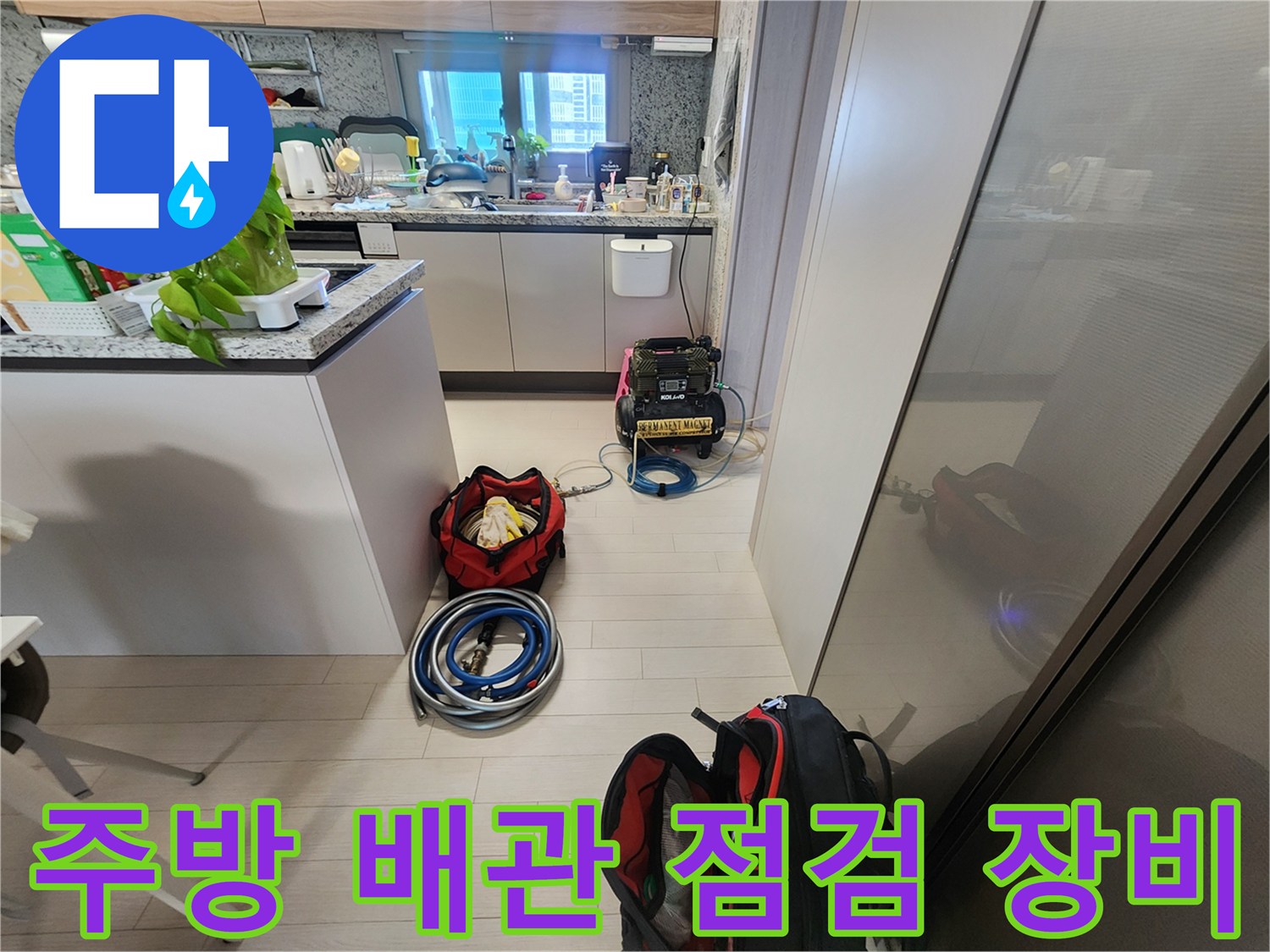 싱크대 하부장 주변에 배치된 배관 점검용 전문 장비 세트