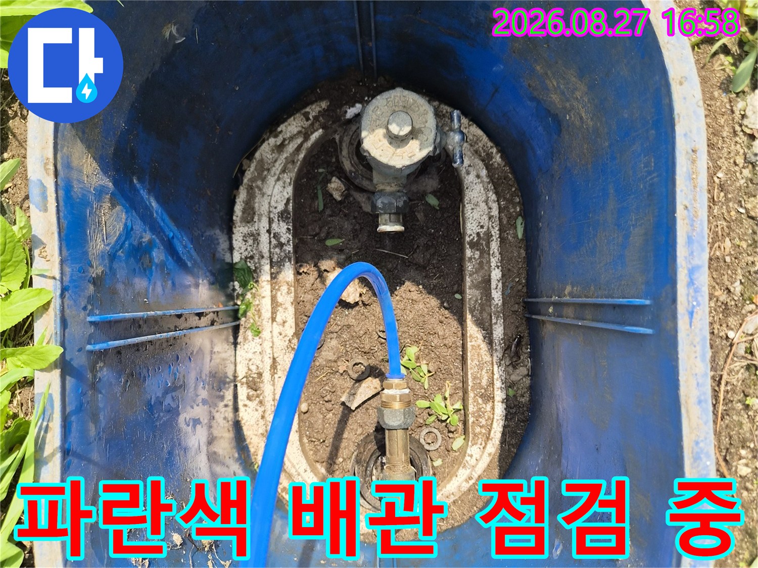파란색 호스가 연결된 수도 계량기 부근의 배관 점검 모습입니다.