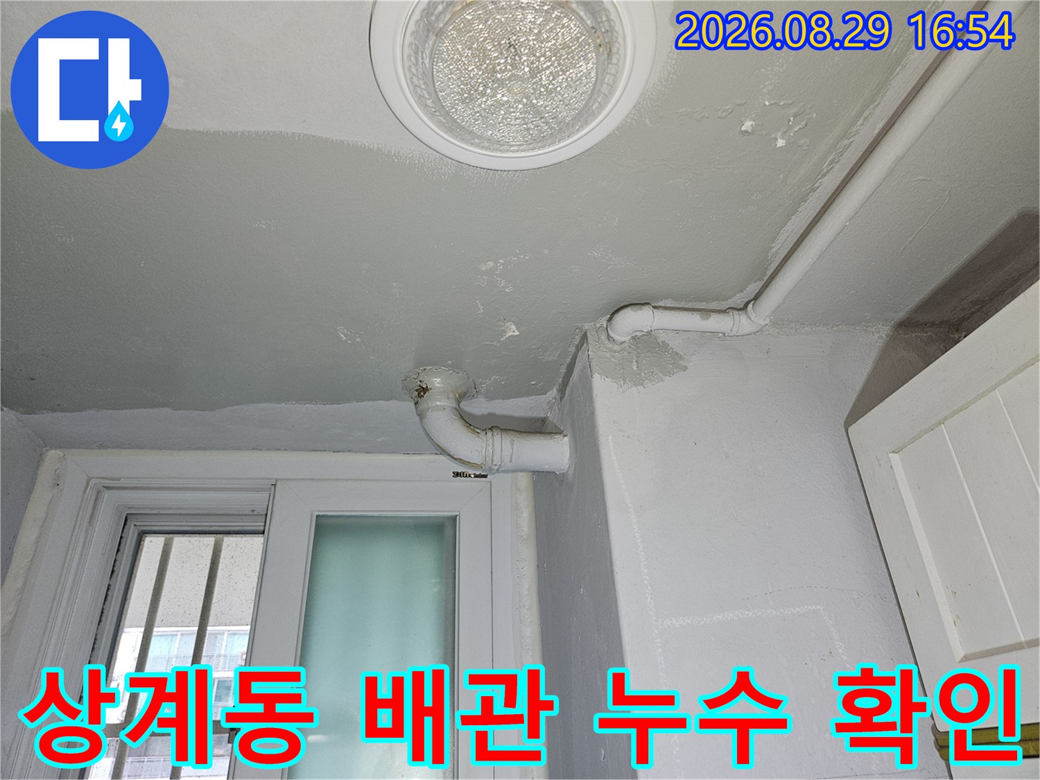상계동 다용도실의 천장 배관 및 바닥 마감재 상태를 촬영한 사진입니다.