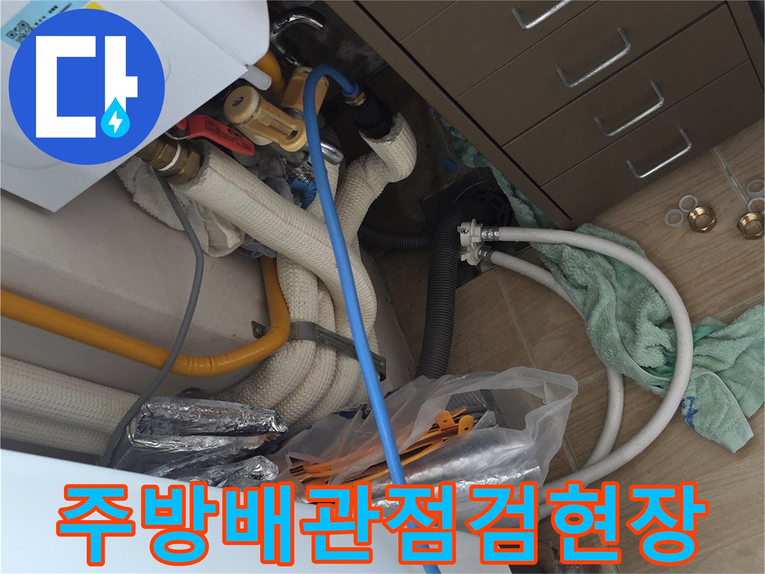 싱크대 하단부의 복잡한 급수 및 배수 배관 상태