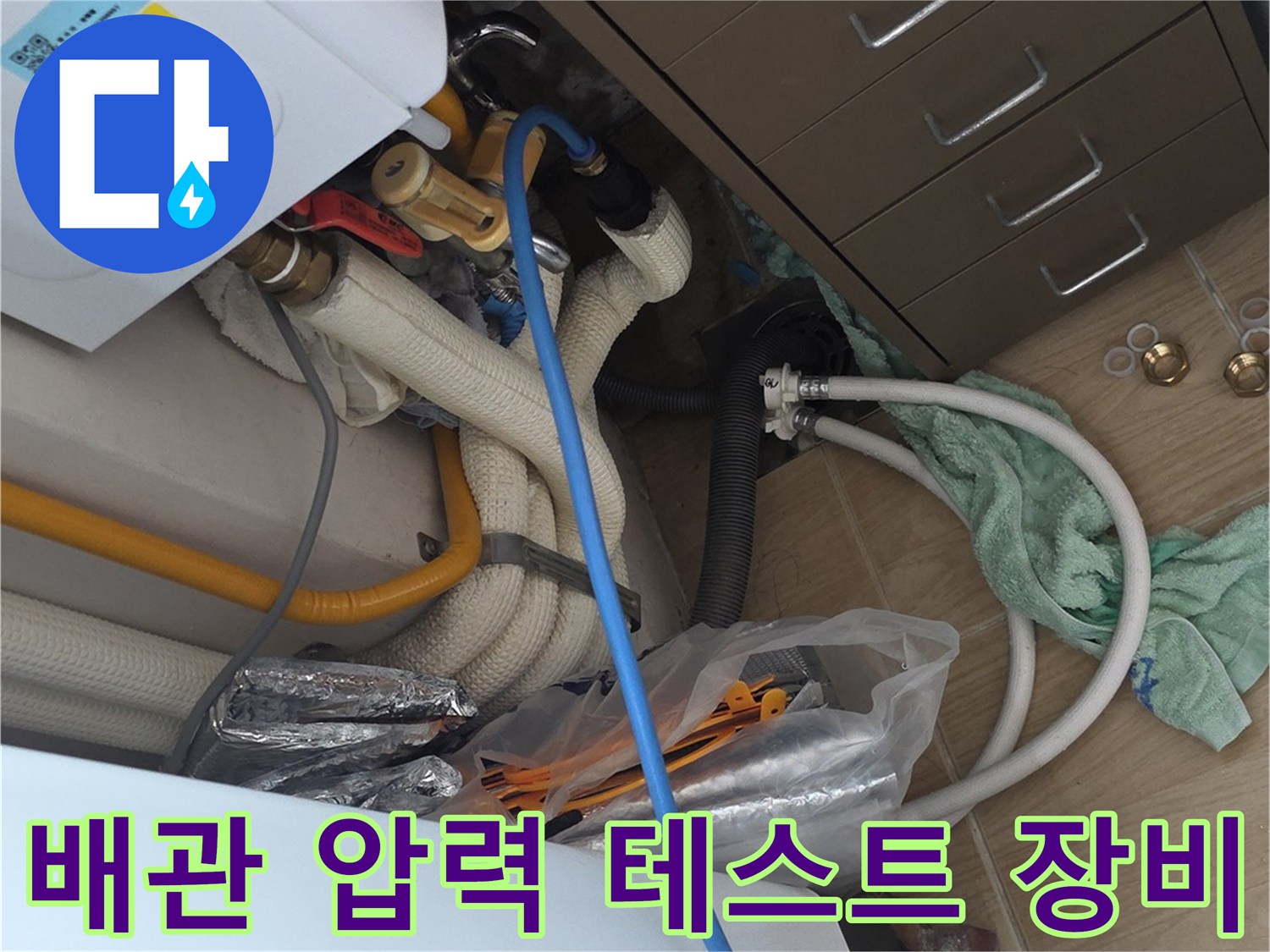 싱크대 하부장 내부의 누수 탐지용 공압 장비와 배관들