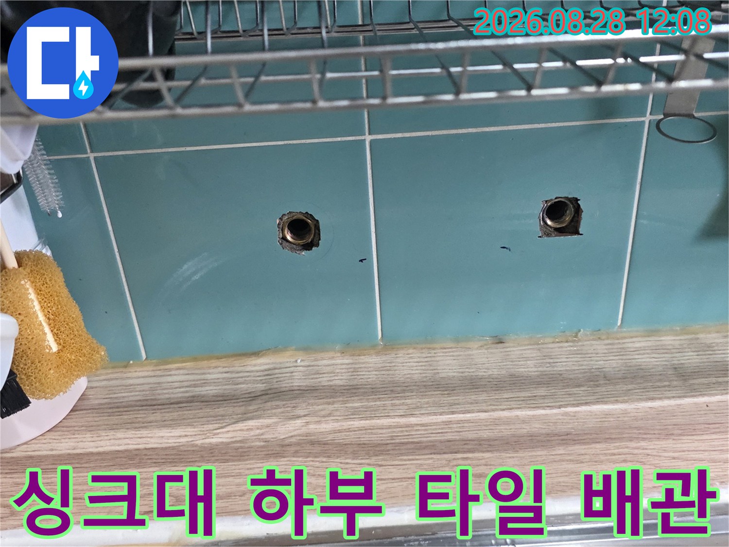 주방 싱크대 내부-타일에 노출된 배관 입구와 주변 상태
