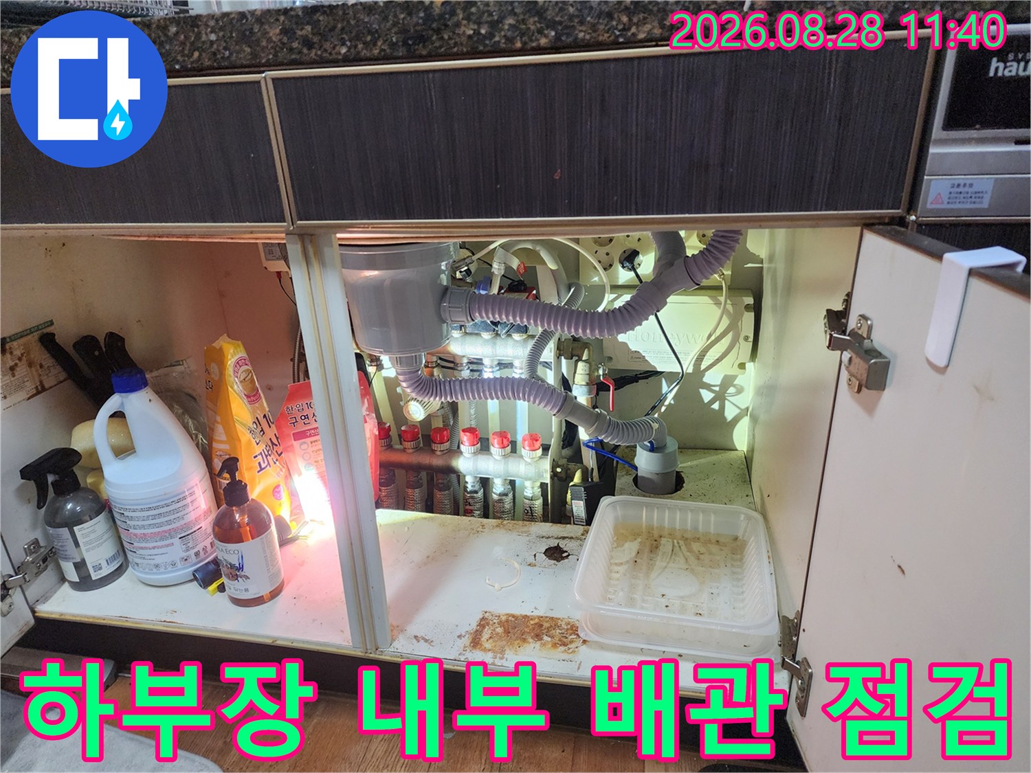 싱크대 하단 장 내부의 에어컨 드레인 호스와 싱크대 배관 연결 부위 확인