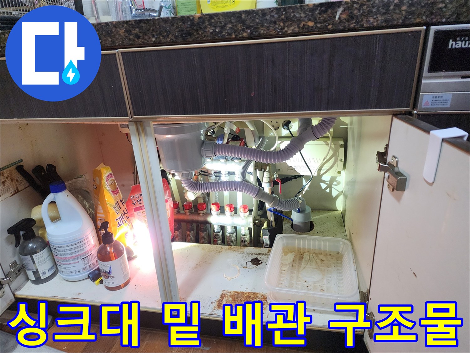 싱크대 하부장 내부의 에어컨 배수 호스 및 각종 배관 연결 상태