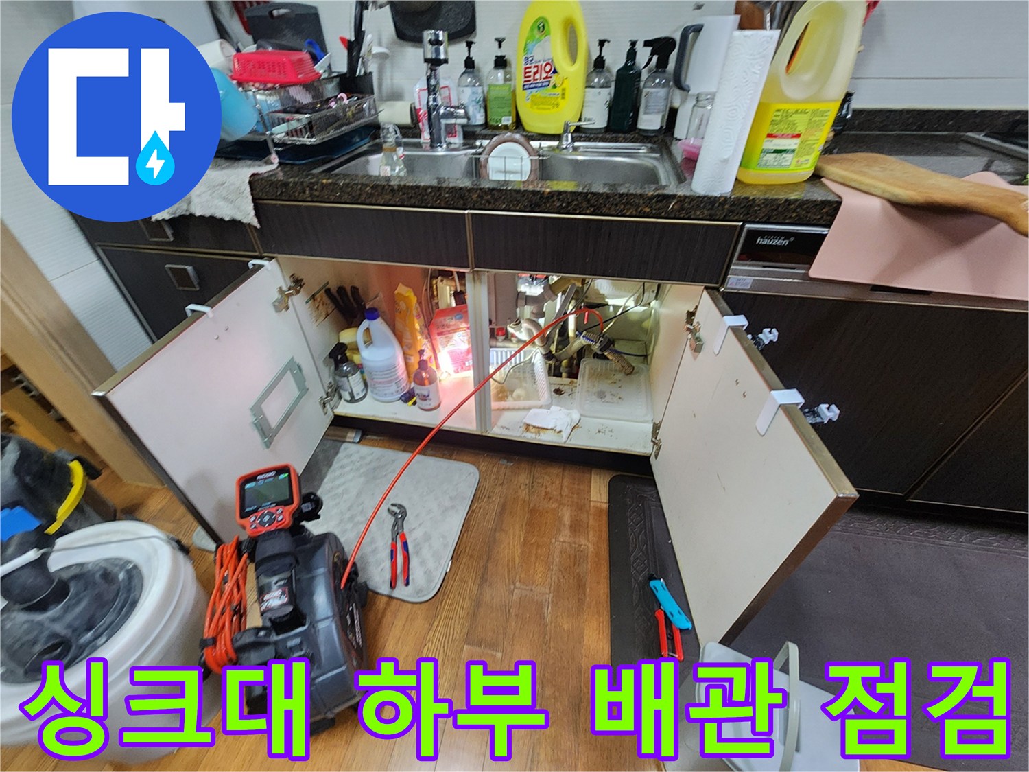 주방 싱크대 하단 배관과 점검 장비 모습