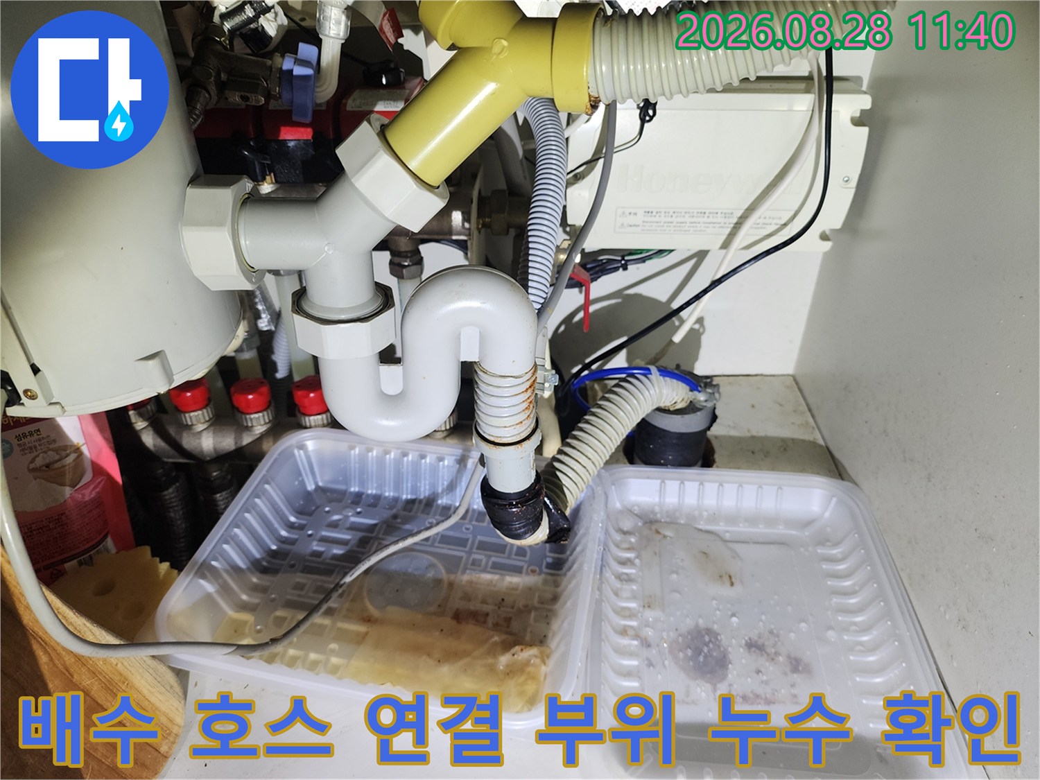 하부장 내부 배수 호스와 흰색 유연 관의 연결 상태를 정밀하게 촬영한 사진