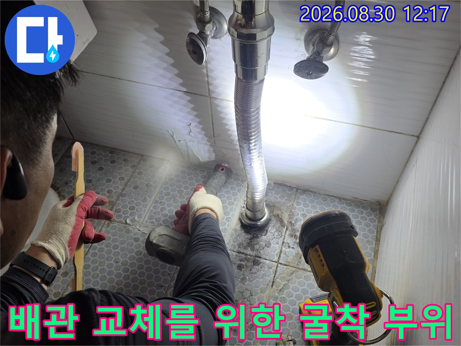 세면대 아래 배관 수리를 위해 타일을 제거한 현장 모습