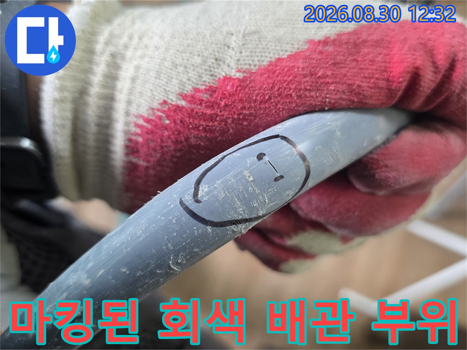 작업용 장갑을 낀 손이-배관의 누수 지점을 가리킴