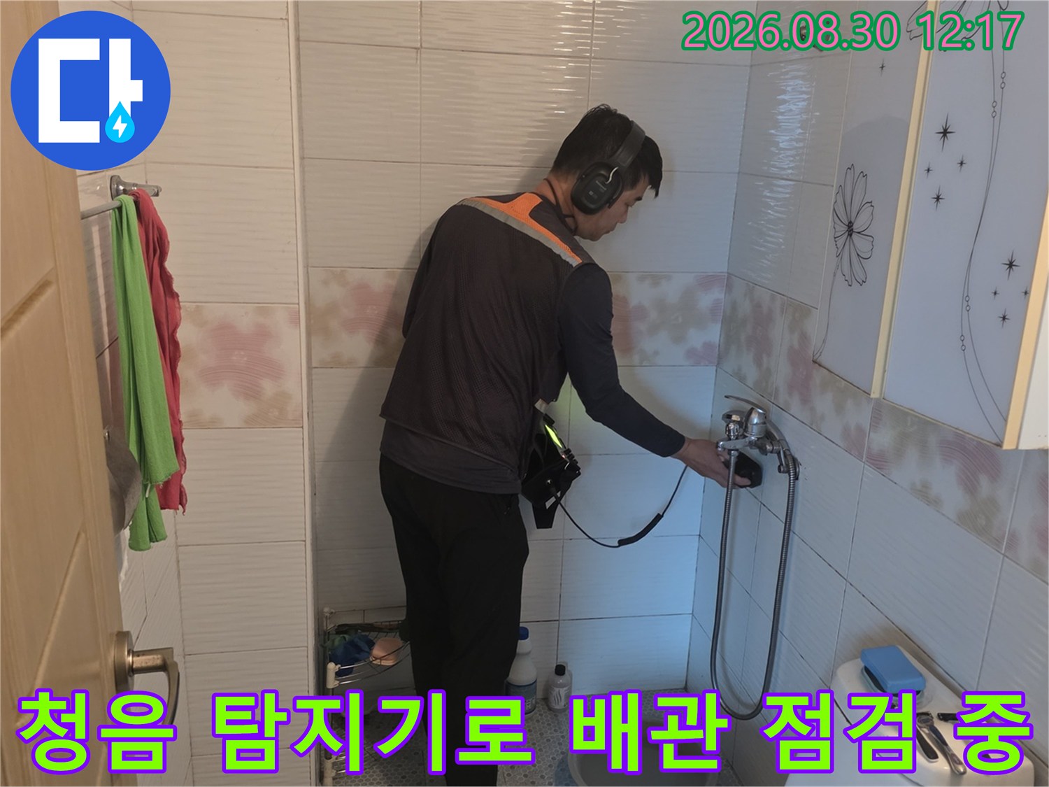 전문 엔지니어가-청음 탐지기를 사용하여-화장실 수도 배관의 누수 지점을 정밀하게 찾는 모습입니다.
