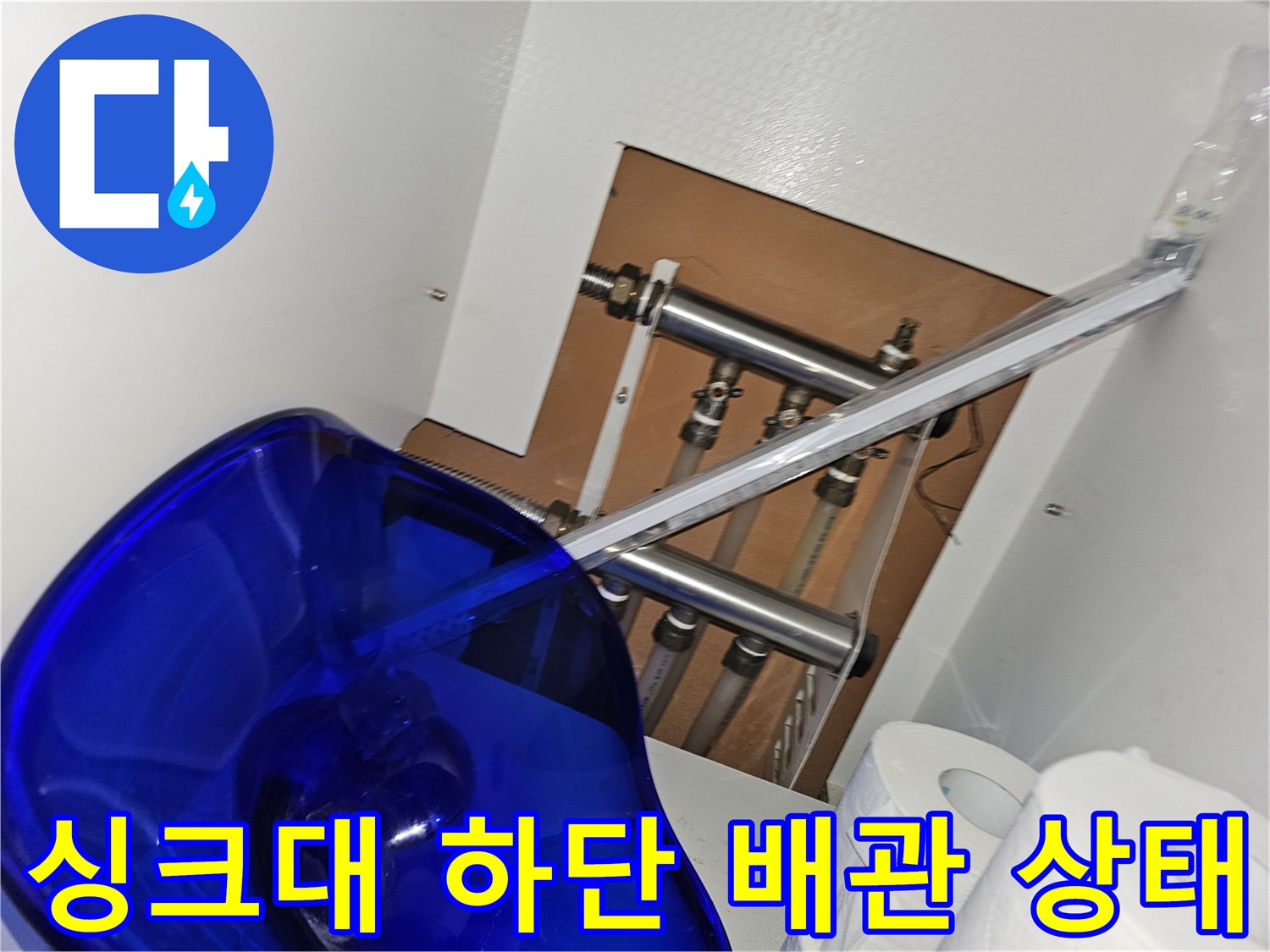 싱크대 하부장 내부의 복잡한 수도 배관 라인 촬영
