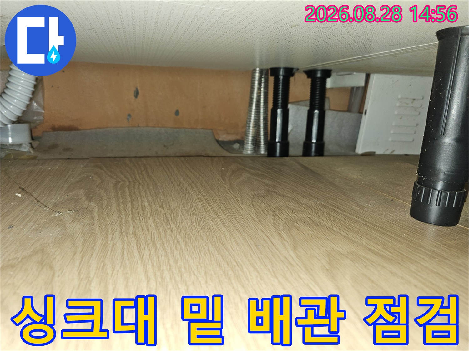싱크대 하부장의 배관과 연결 부위 근접 촬영 이미지