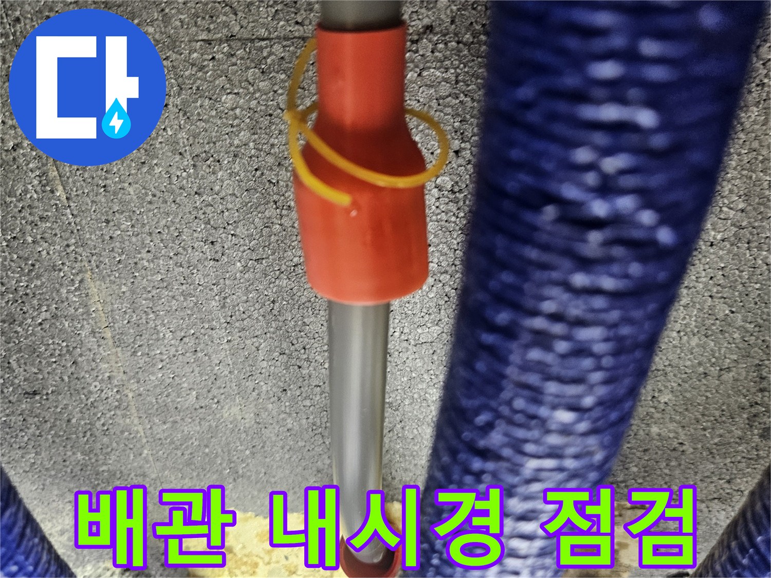 파란색 보온재로 감싸진 배관 사이로 내시경 카메라를 투입하는 모습