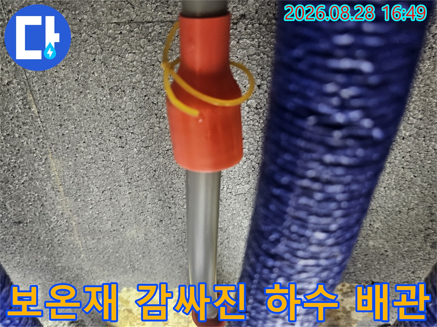 푸른색 보온재가 씌워진-배관과 타공된 벽면의 모습입니다.